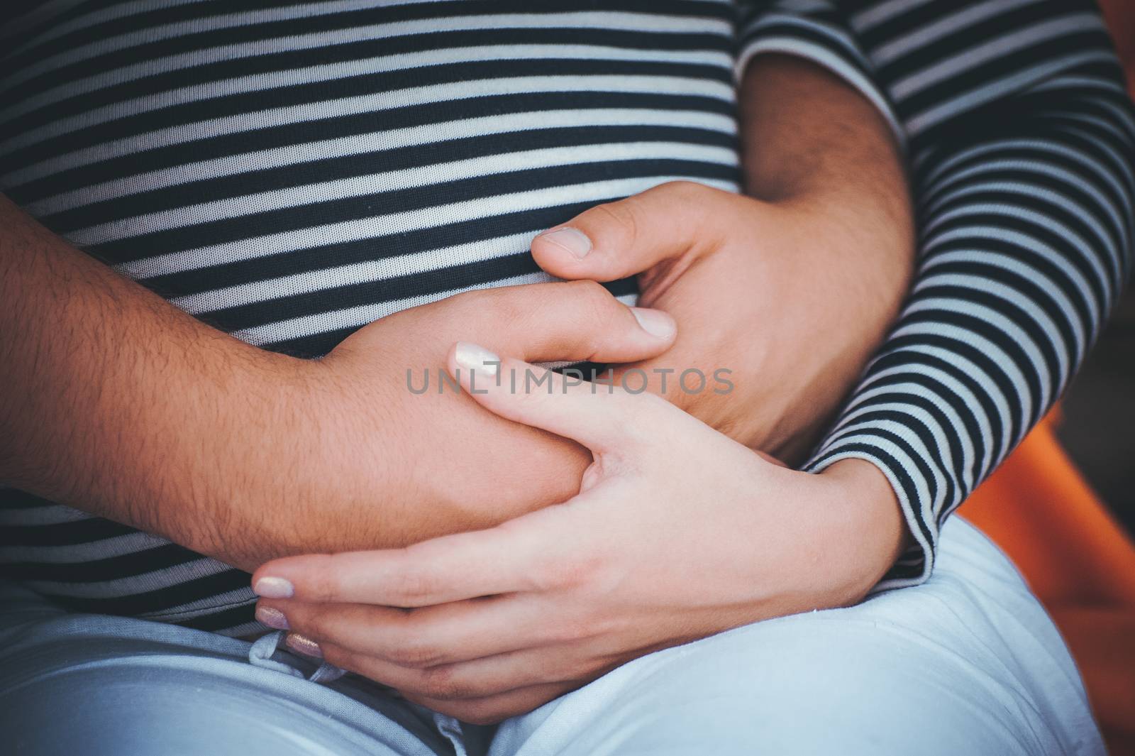 men holds hands on belly of pregrant women no face 