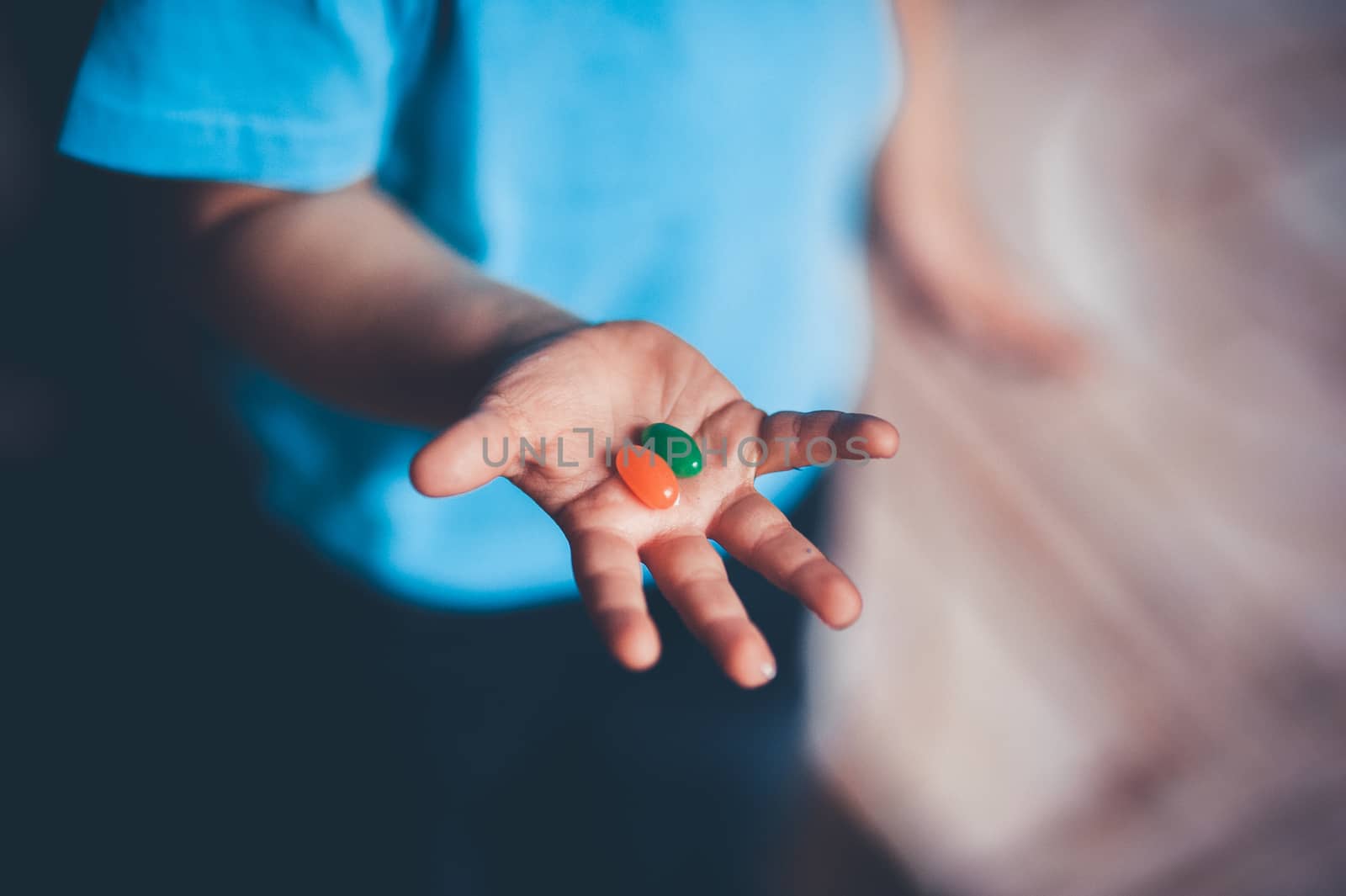 child holds candies on his hand  by fesenko