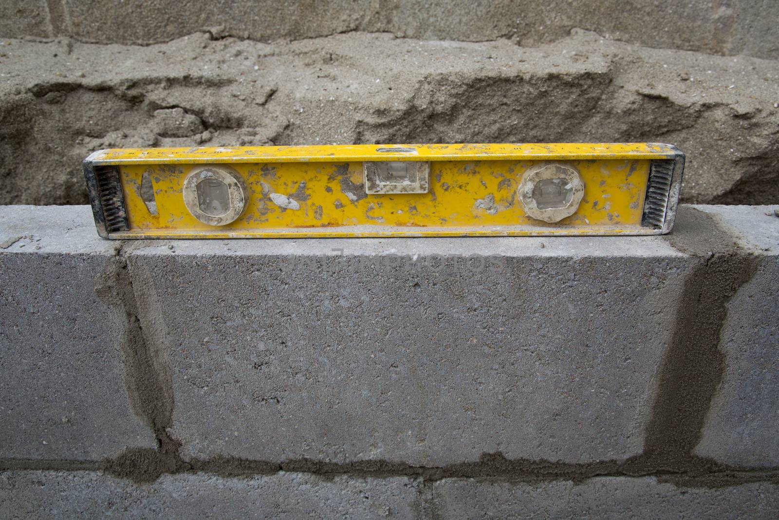 Yellow spirit level on a constructed wall outdoors