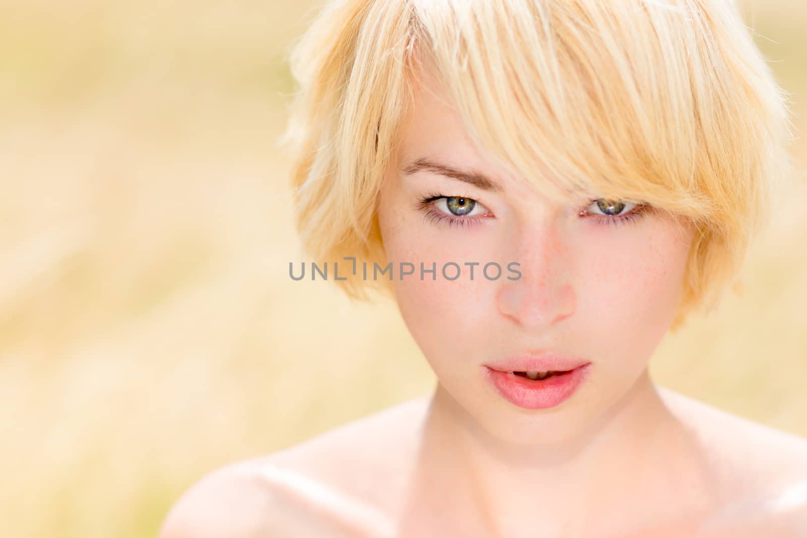 Portrait of  beautiful young Caucasian woman outdoor in the meadow on a sunny summer day.