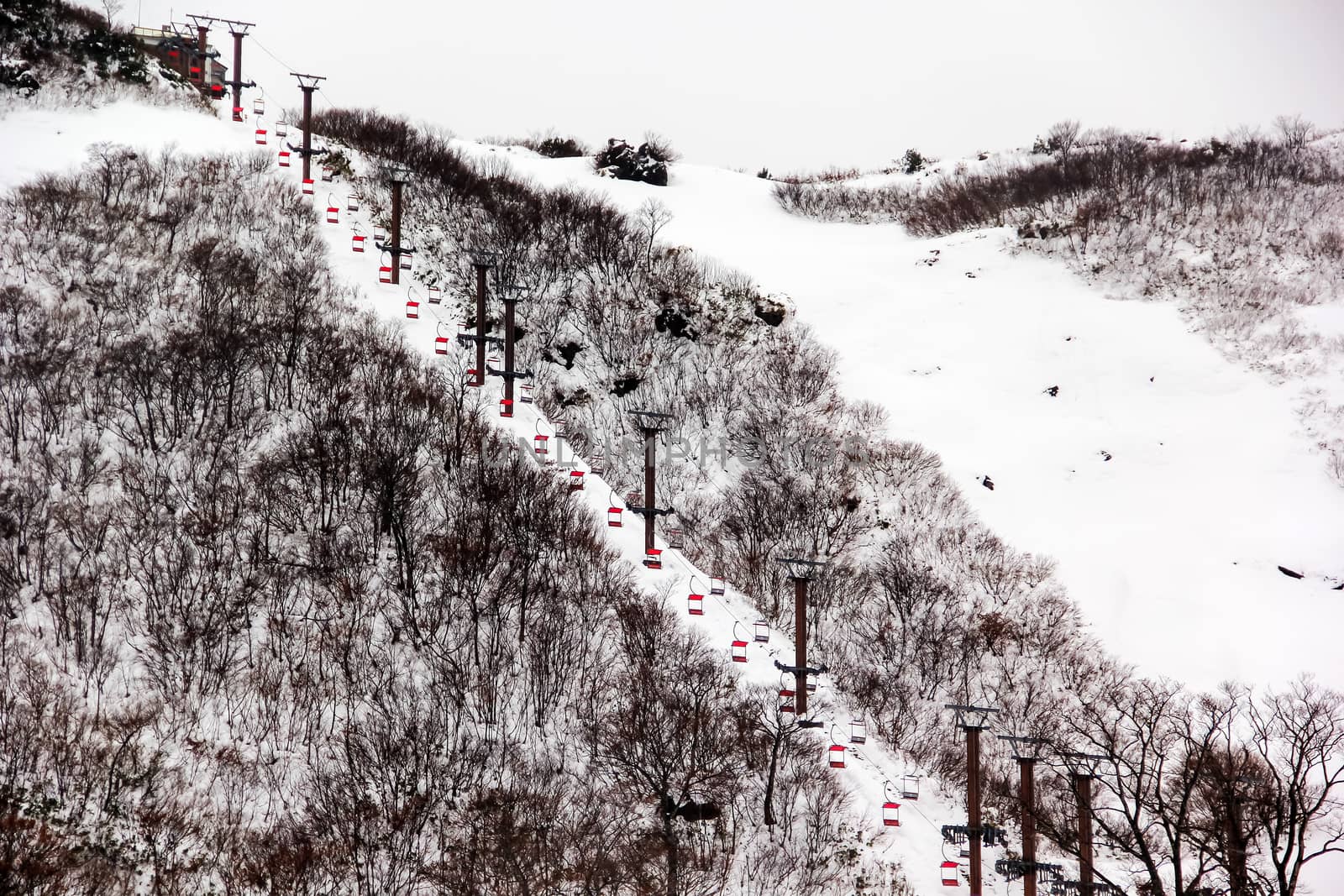 Ski chair lift with skiers on mountain