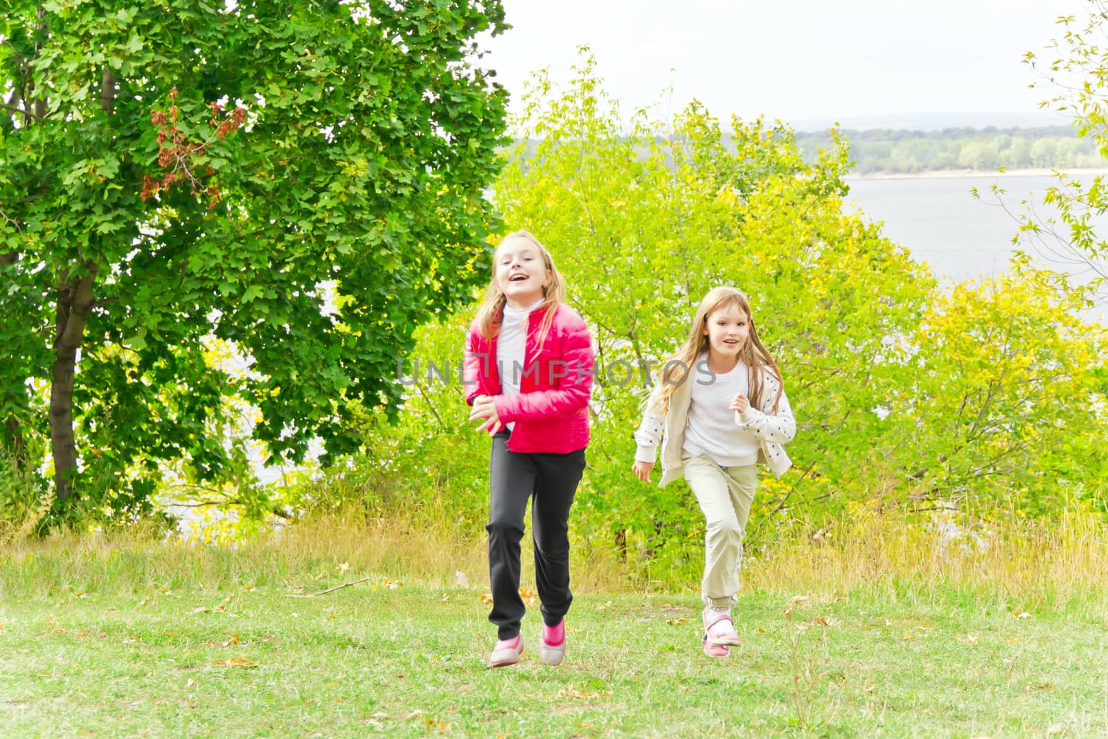 Photo of two running girls in summer