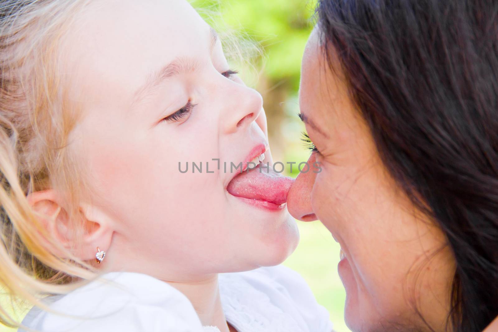 Photo of kissing mother and daughter in summer