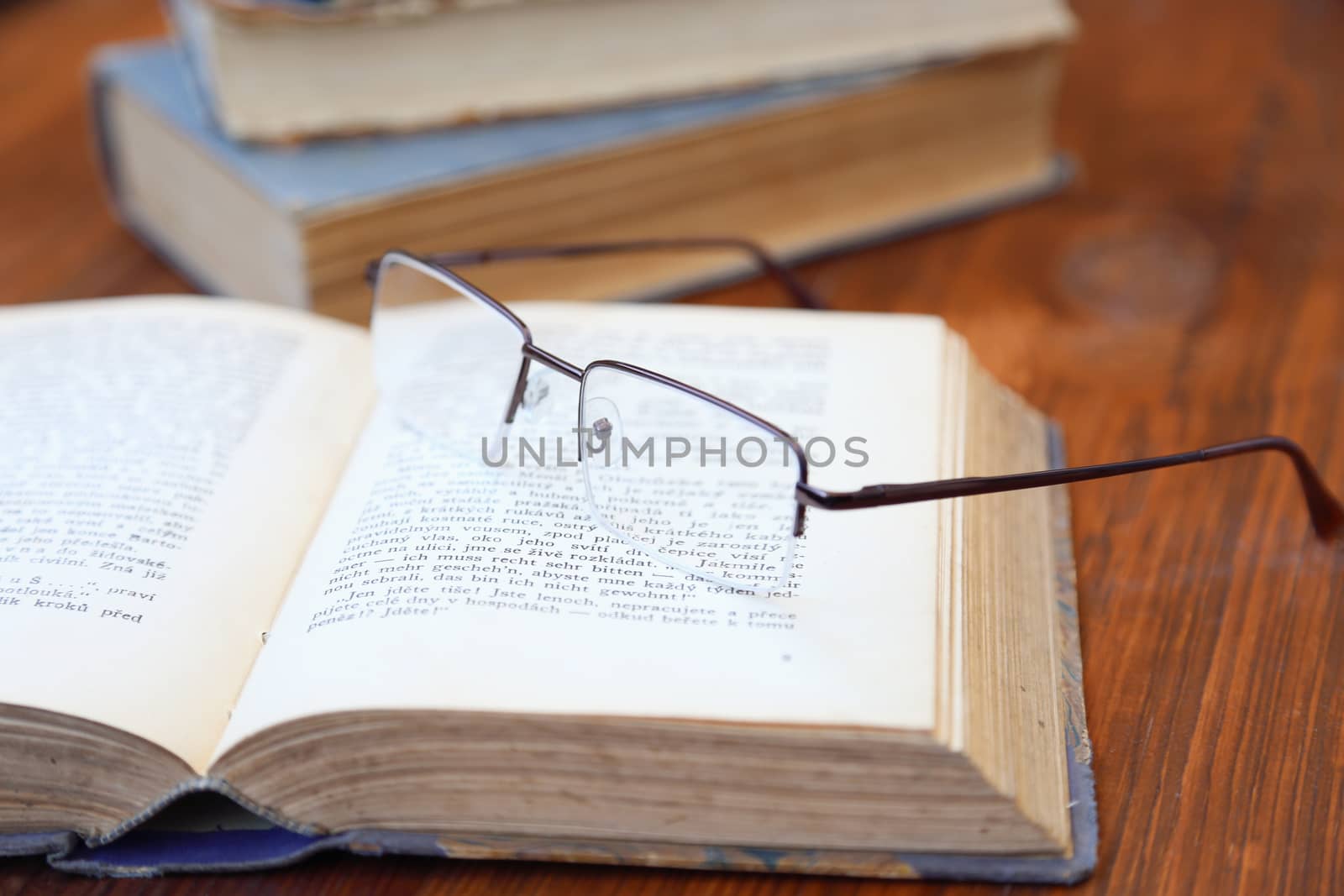 glasses lie on a few opened age-old books