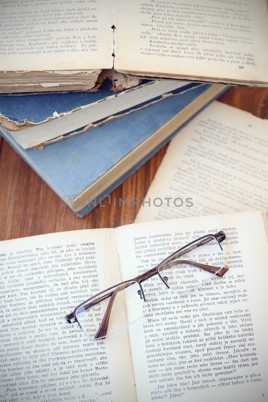 glasses lie on a few opened age-old books