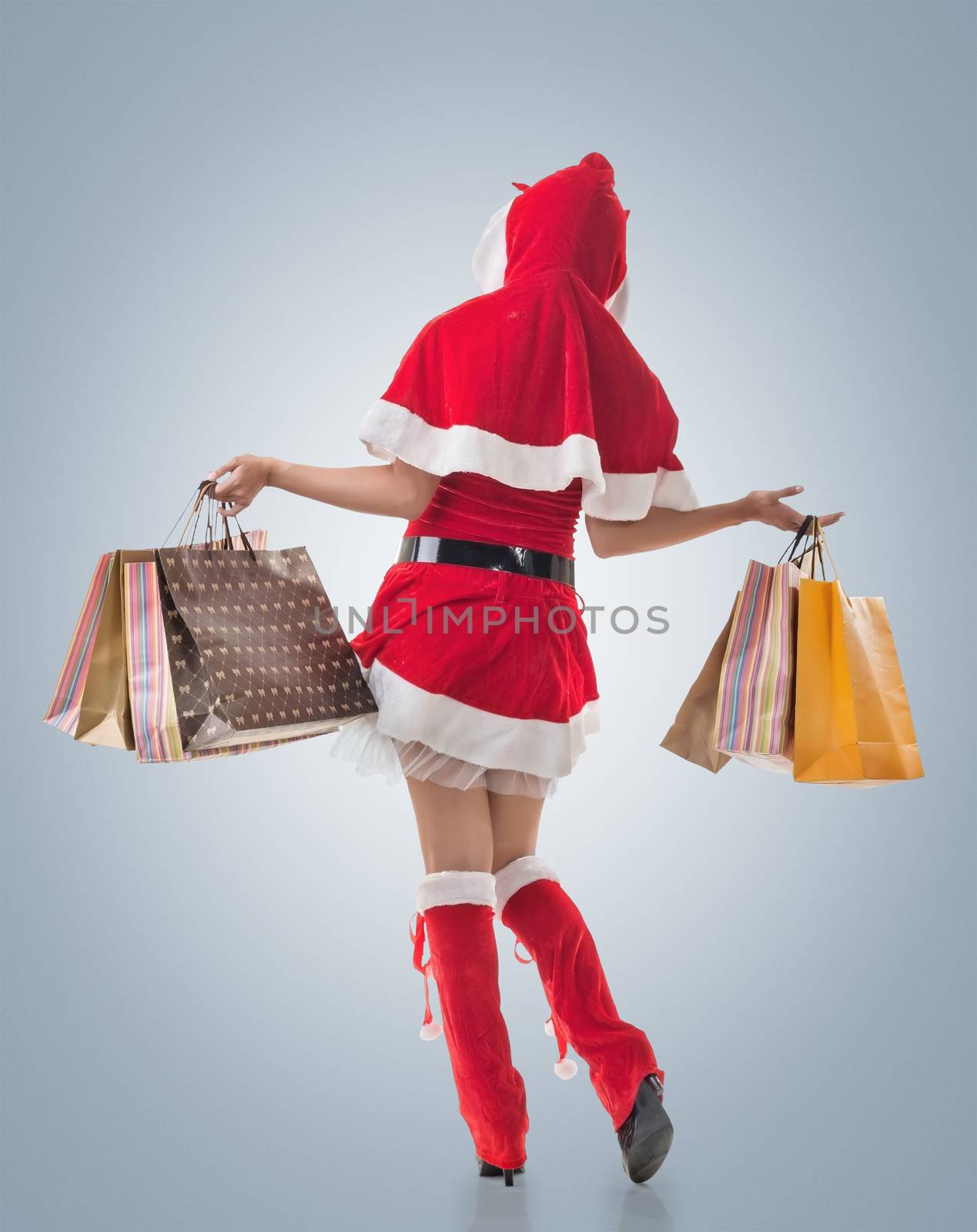 Christmas girl holding shopping bags, rear view portrait isolated.