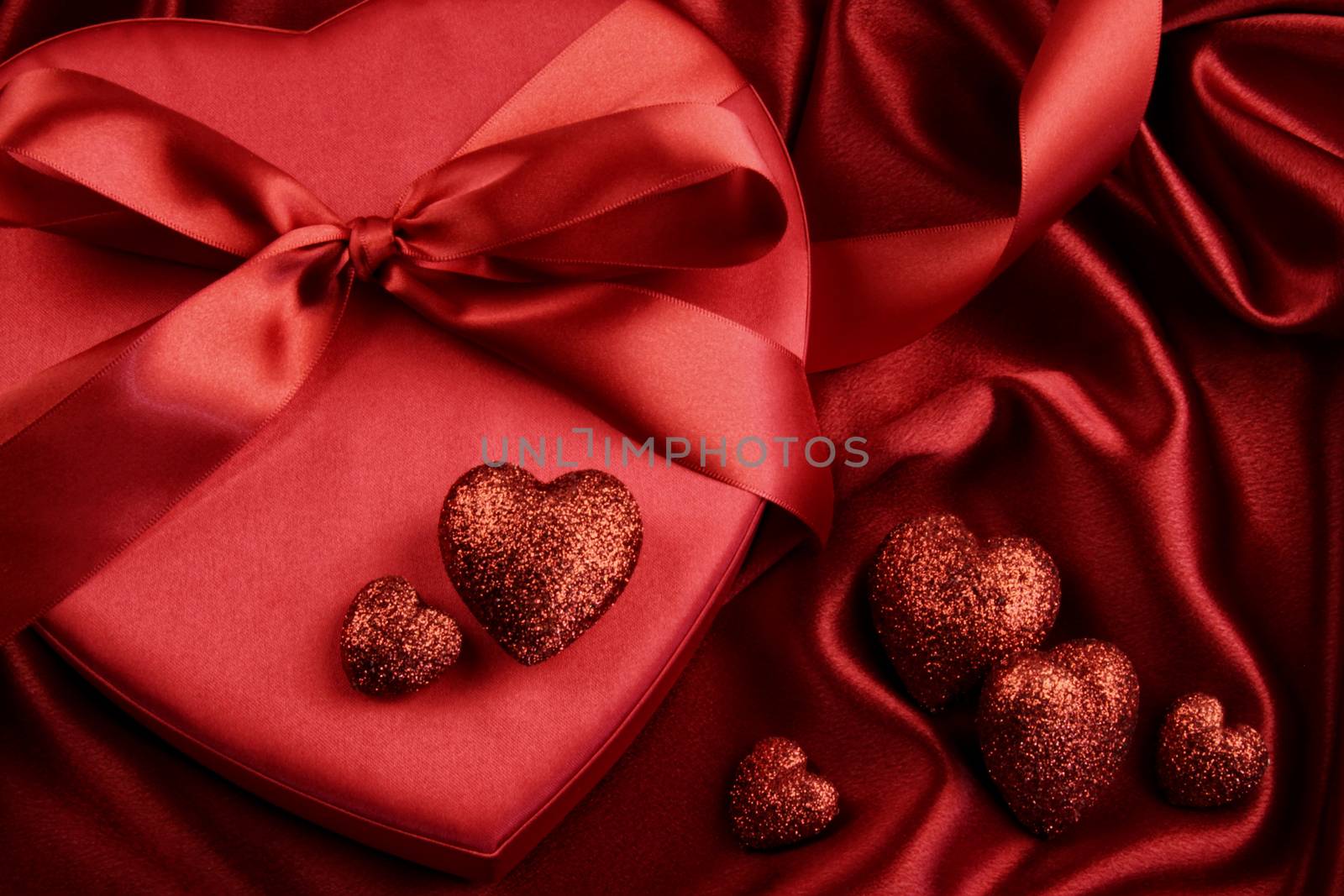 A group of red hearts on satin background by Sandralise