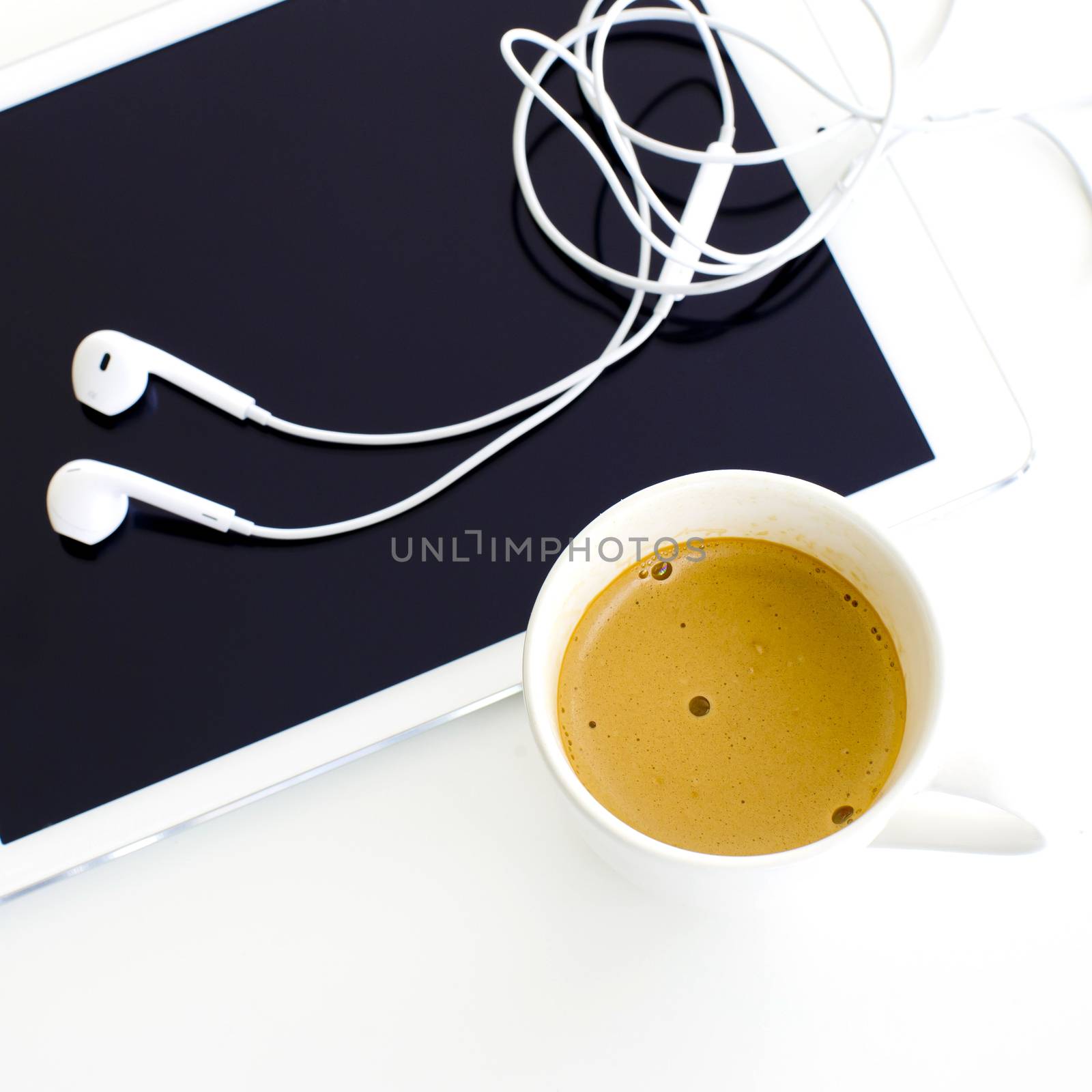 Digital tablet and earphone and white coffee cup on white background