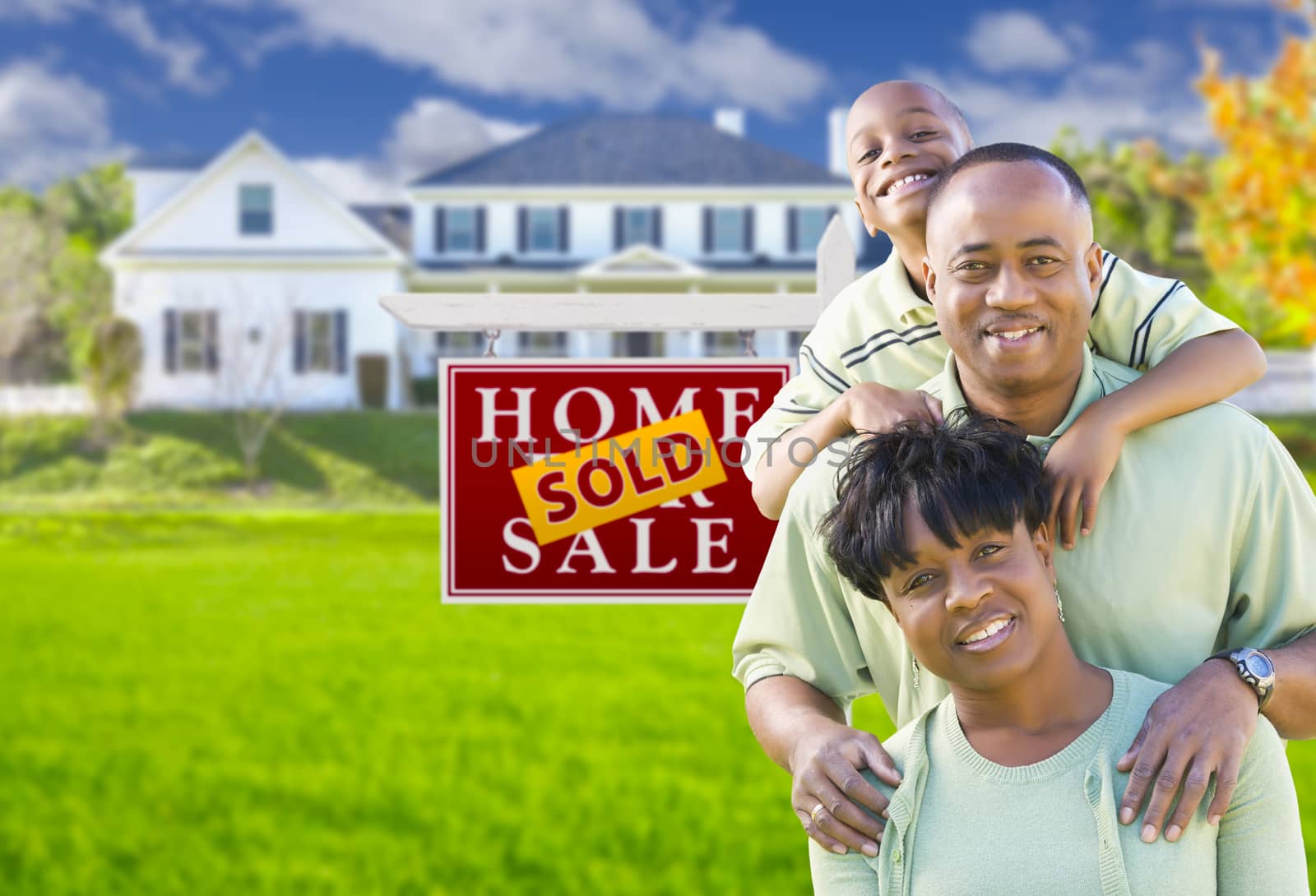 African American Family In Front of Sold Sign and House by Feverpitched