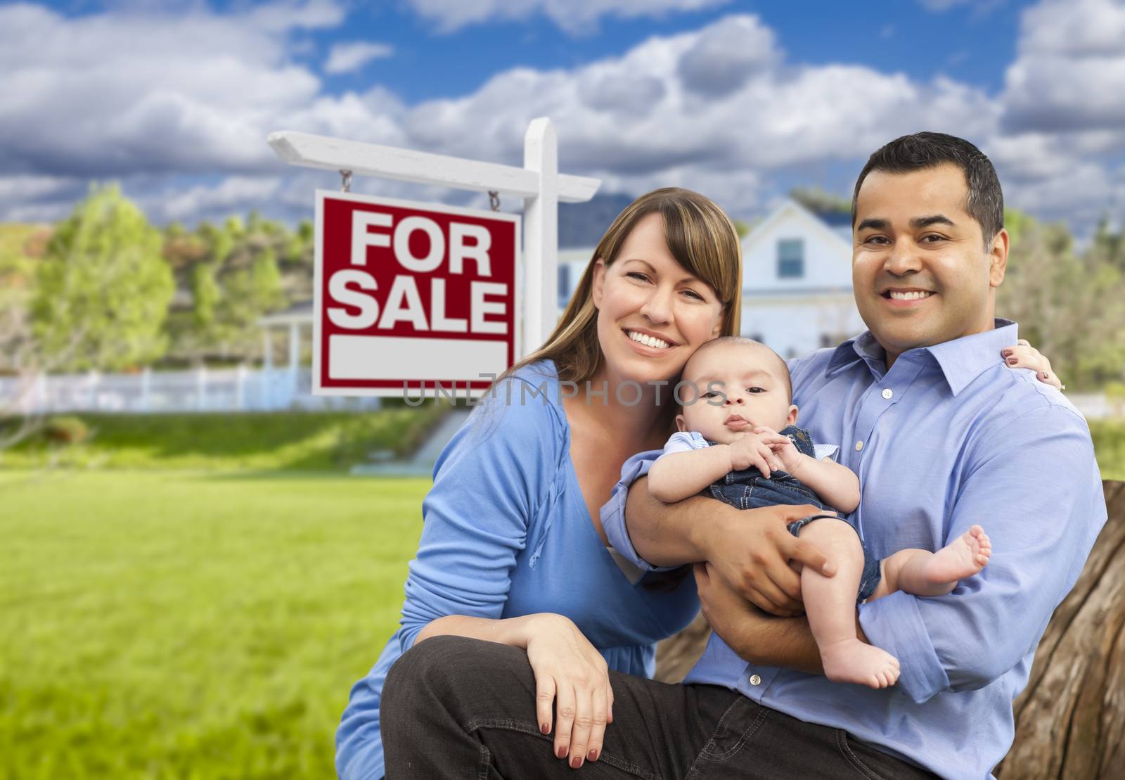 Young Family in Front of For Sale Sign and House by Feverpitched