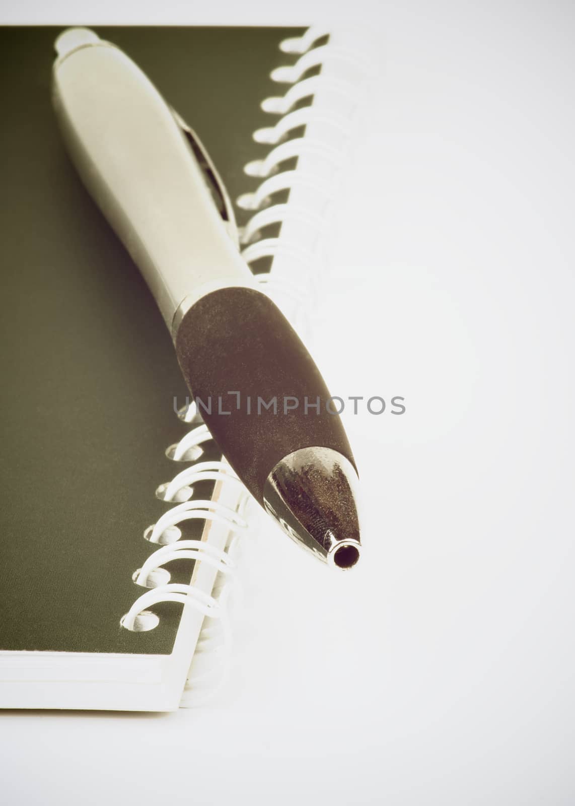 Black and Silver Pen on Dark Green Spiral Notepad on white background. Retro Styled