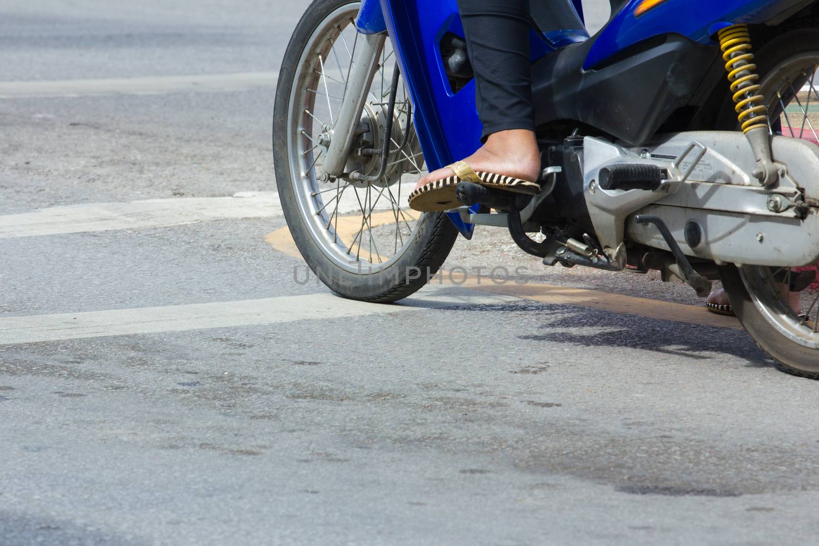 motorcycle stop at white line on junction waiting for traffic light in Thailand