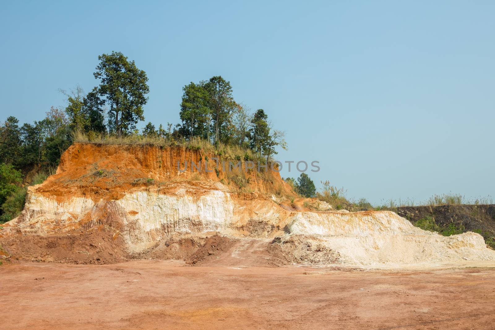 hill is digged by excavator, its soil are sold, in Thailand