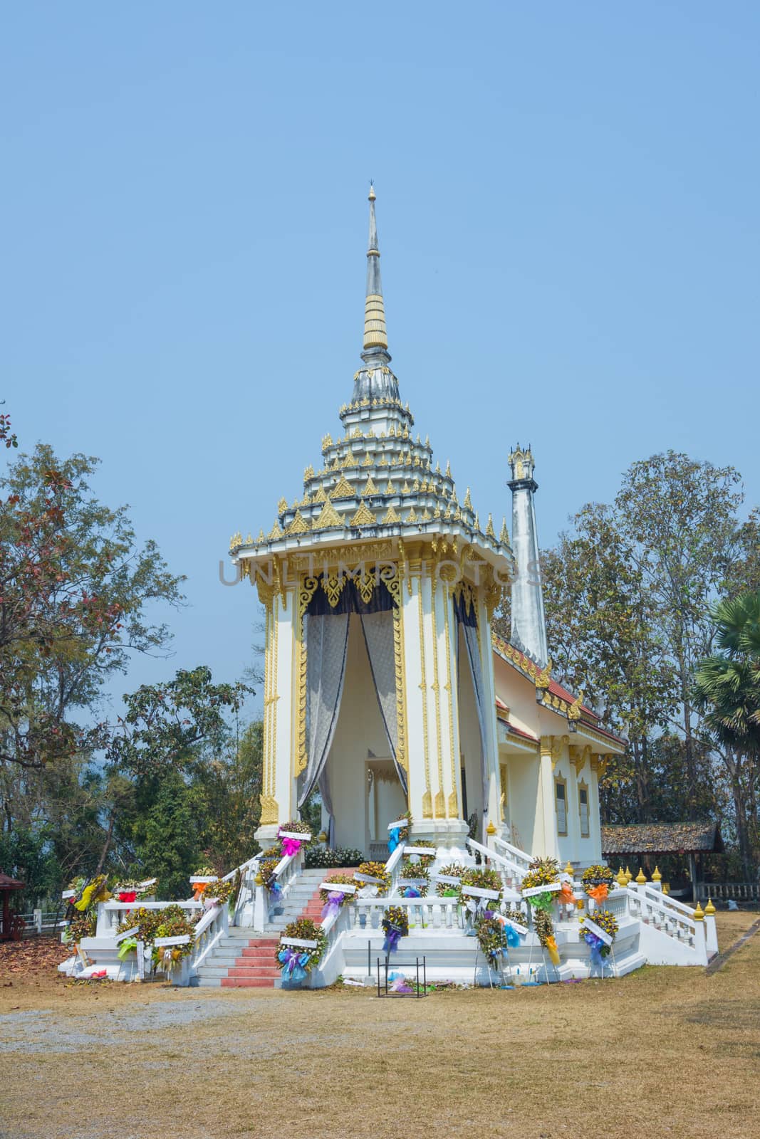 Thai style crematory with wreaths on blue sky background