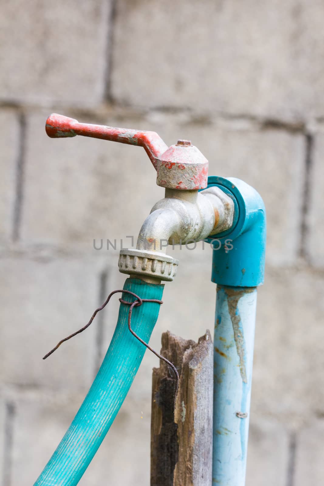 old water tap, PVC pipe and green rubber tube in white background