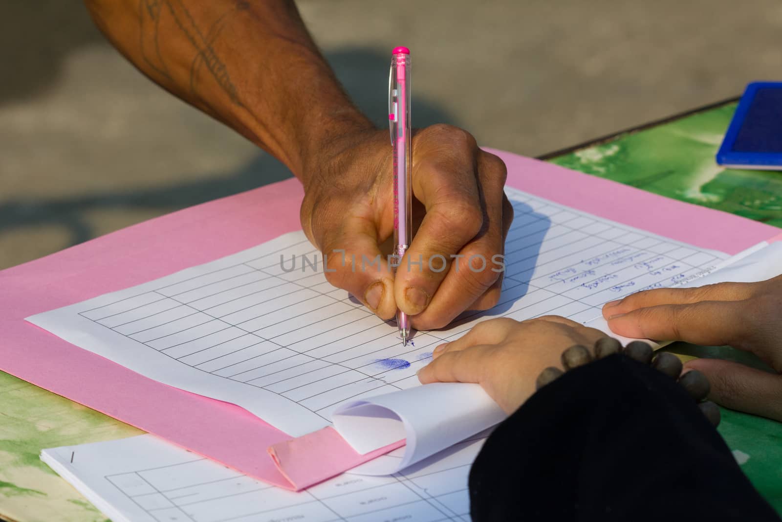 Thai farmer's hands signing a contract.