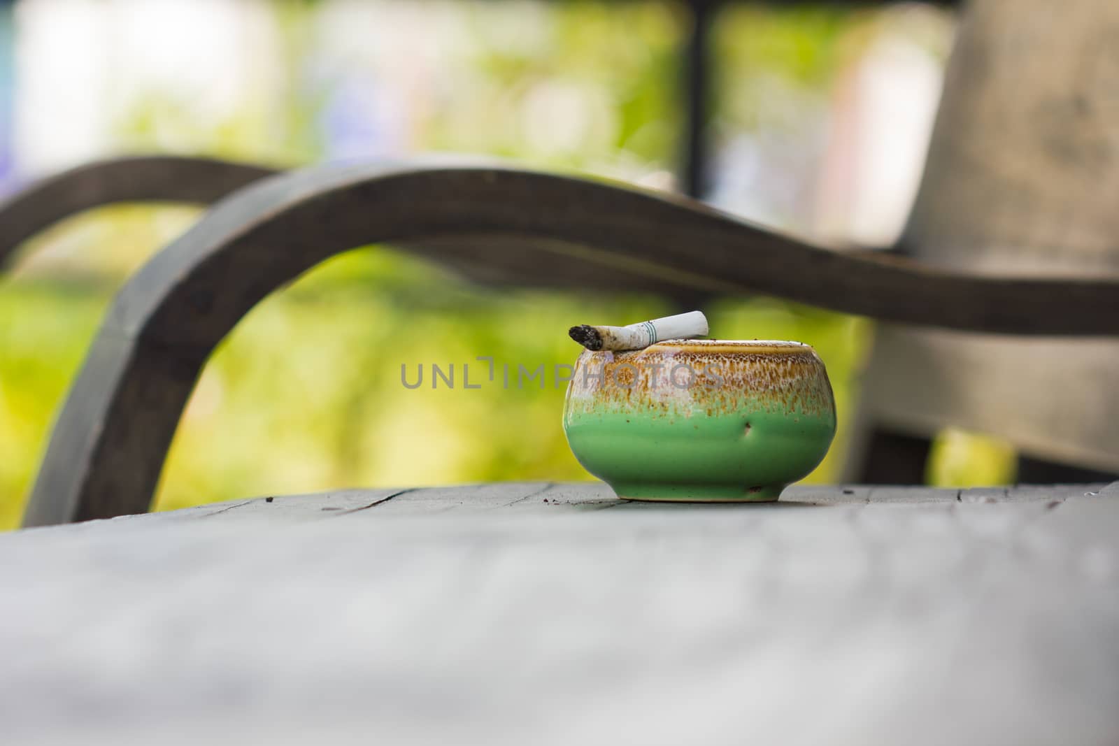 ashtray and dirty cigarette on wooden table