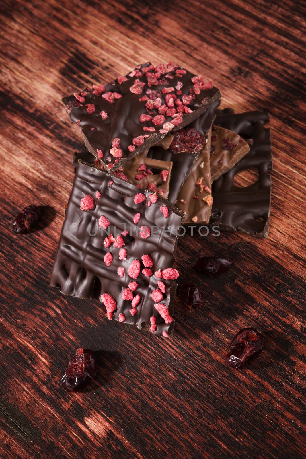 Culinary gourmet chocolate pieces on dark wooden background. Luxurious dark chocolate.