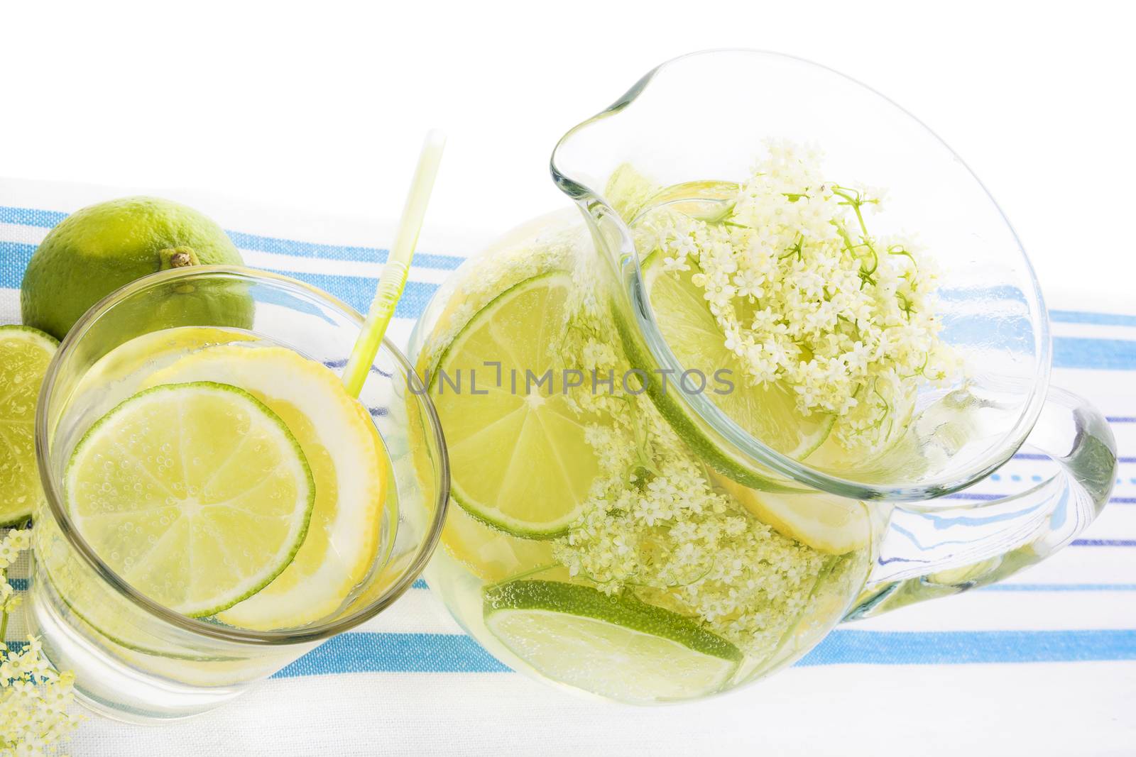 Elderberry lemonade with fresh lemon and lime and elderberry blossom isolated on white background. Fresh summer healthy drink.