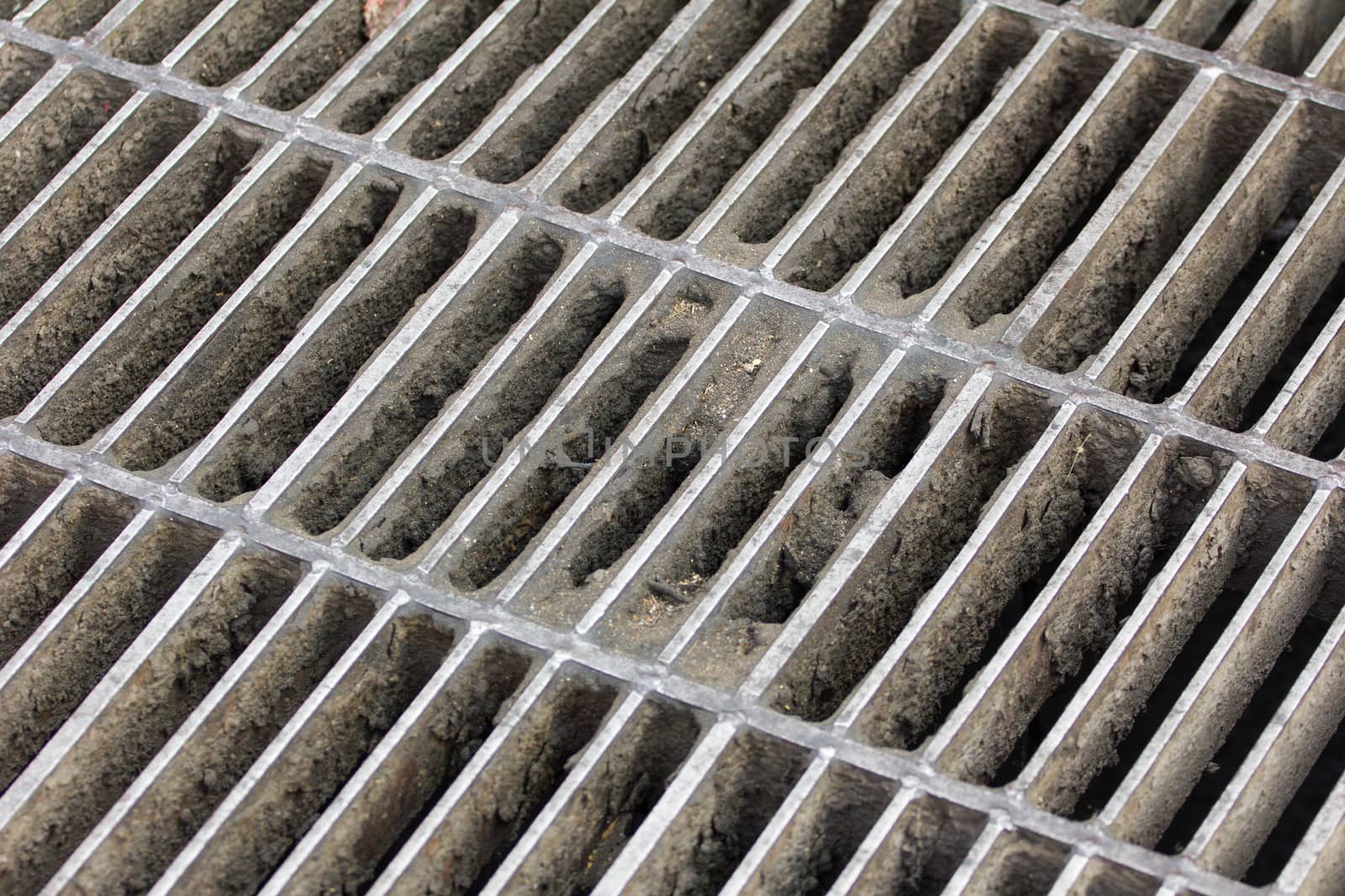 Drain grating on road in Thailand, background
