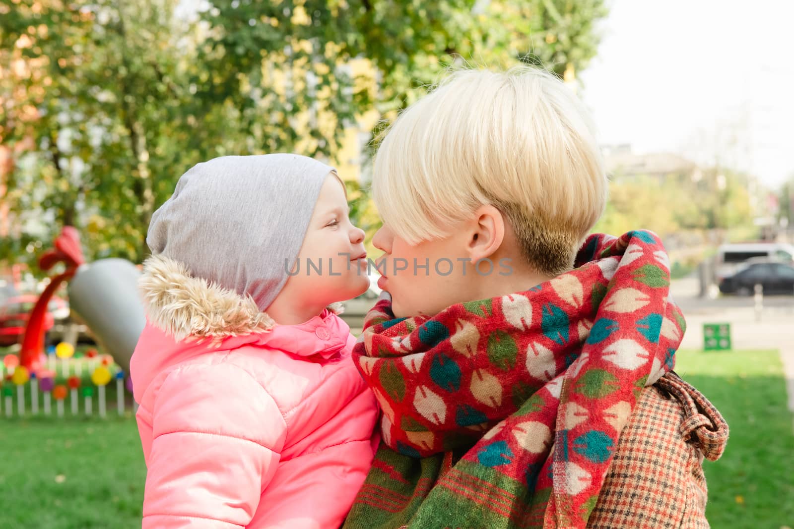 Beautiful Mother And Baby outdoors. Nature. Beauty Mum and her Child playing in Park together. Outdoor Portrait of happy family. Joy. Mom and Baby
