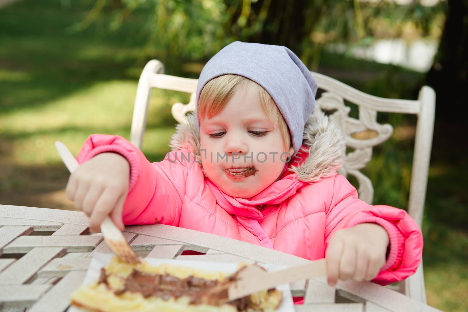 Child eating waffles with chocolate  by sarymsakov