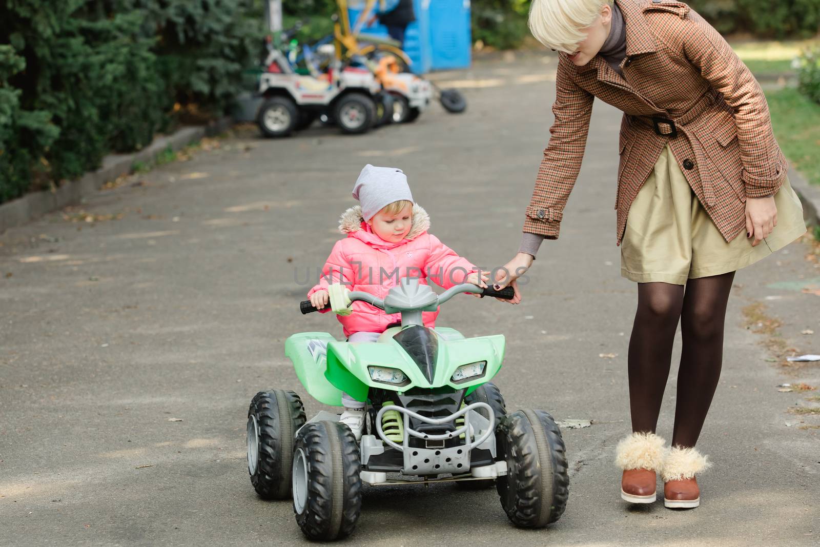 Little girl riding toy car in park by sarymsakov