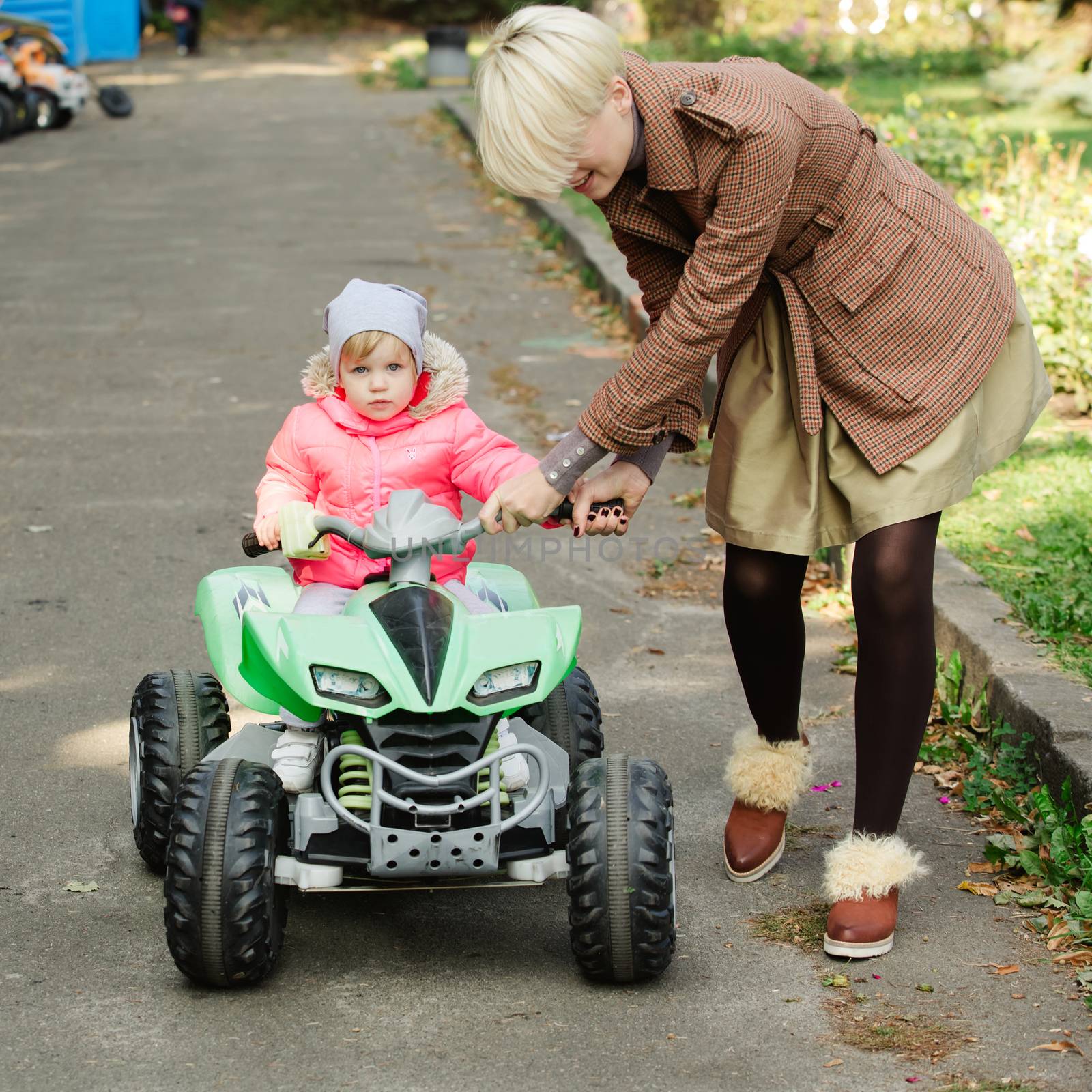 Little girl riding toy car in park by sarymsakov