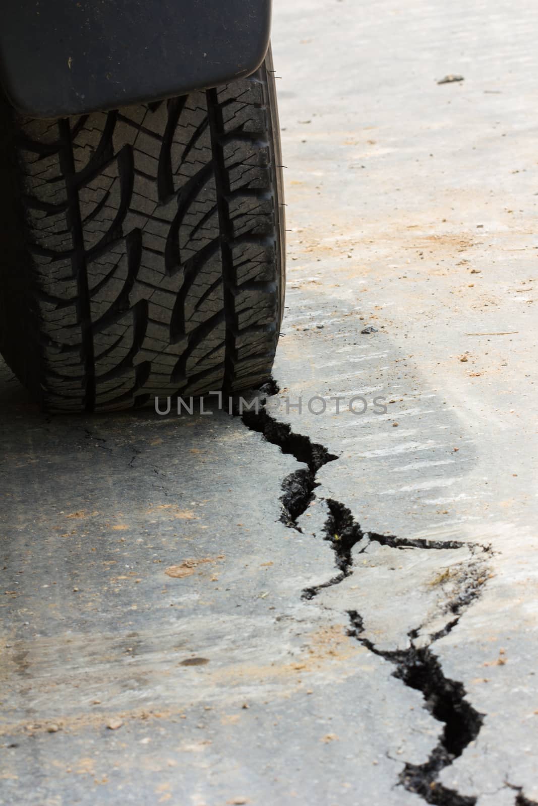 back view of tire tread and cracked asphalt