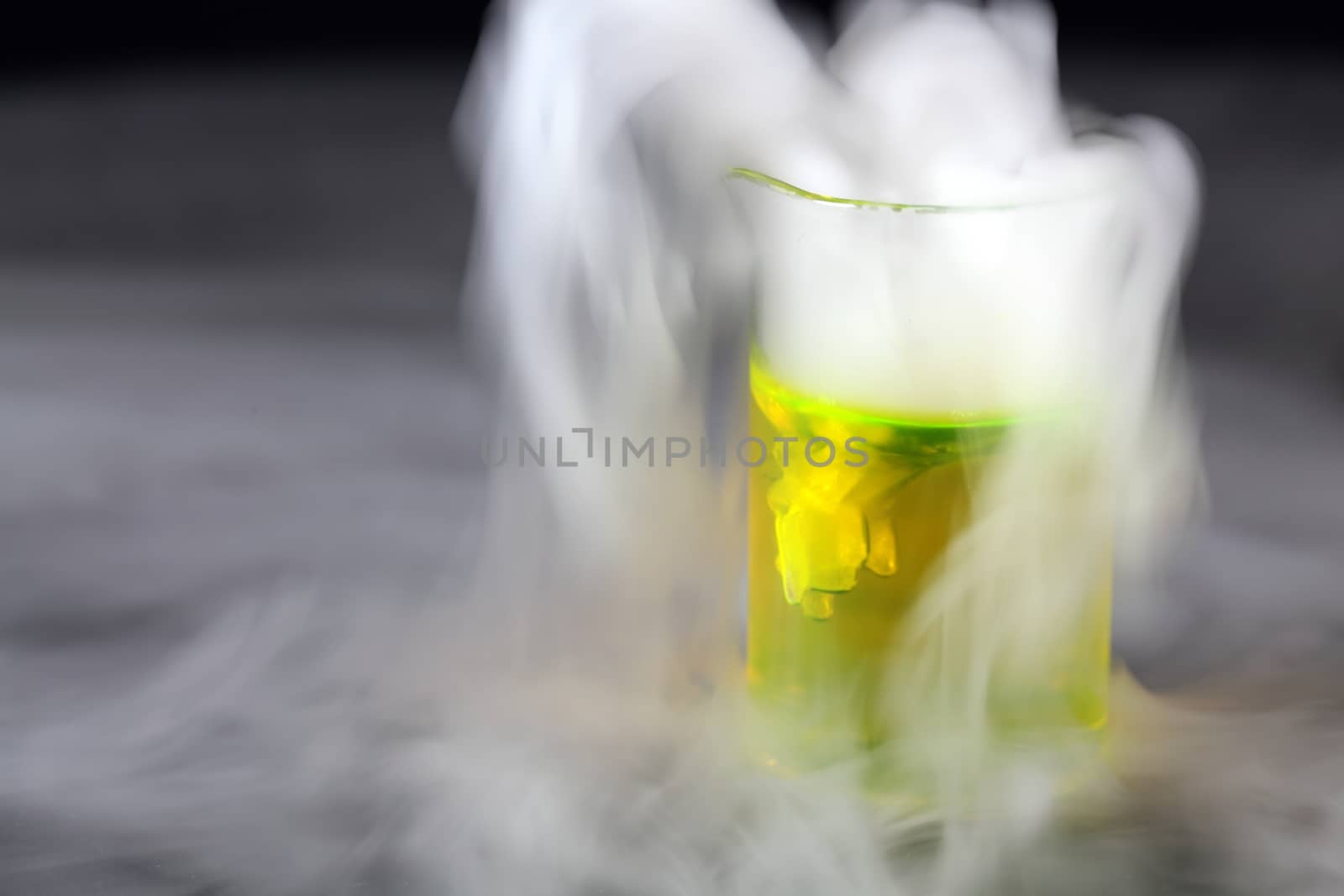 Glass with dry ice and a green fluid