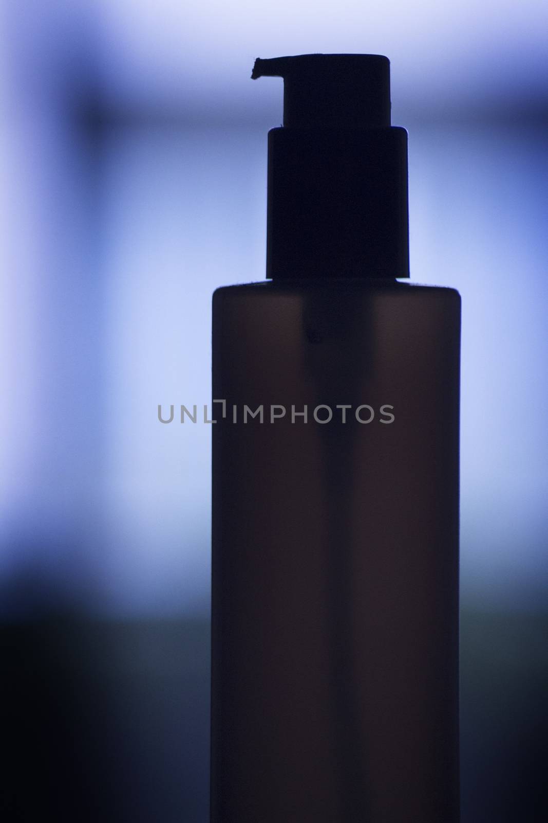 Cosmetics container dispenser blue silhouette photograph.
