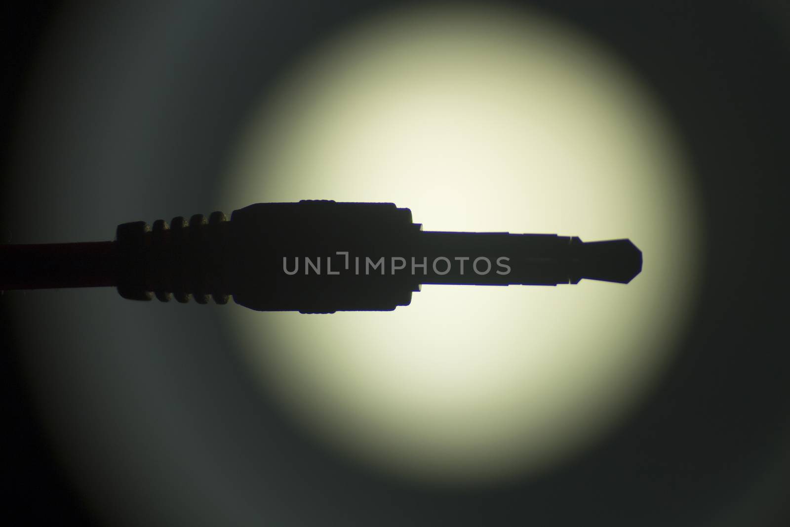Audio cable artistic silhouette in circular light vignette photograph.