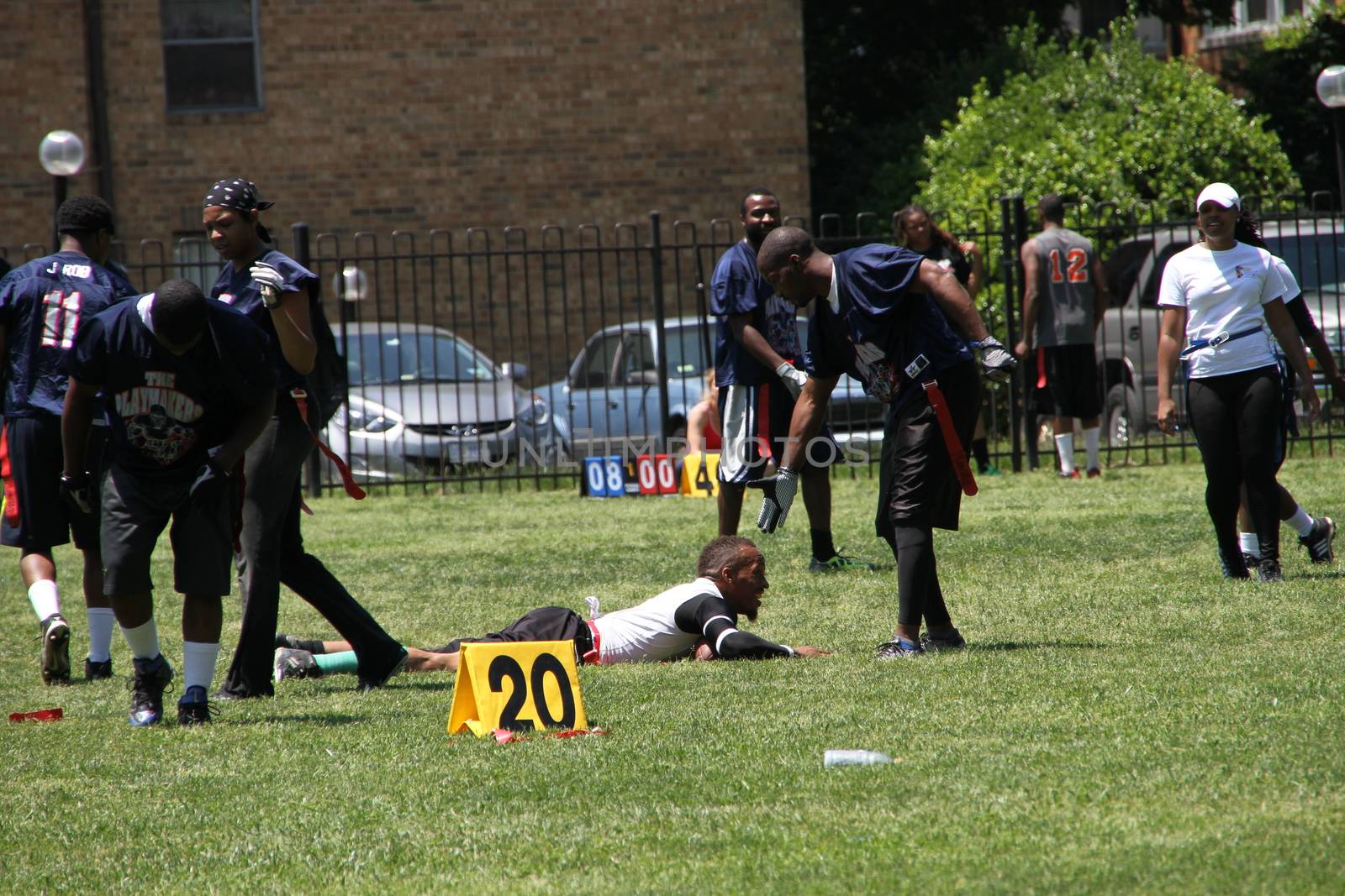 Washington DC, USA - may 19, 2012. African Americans play a game near the College. Honest sport one athlete fell, and the other helps him to rise
