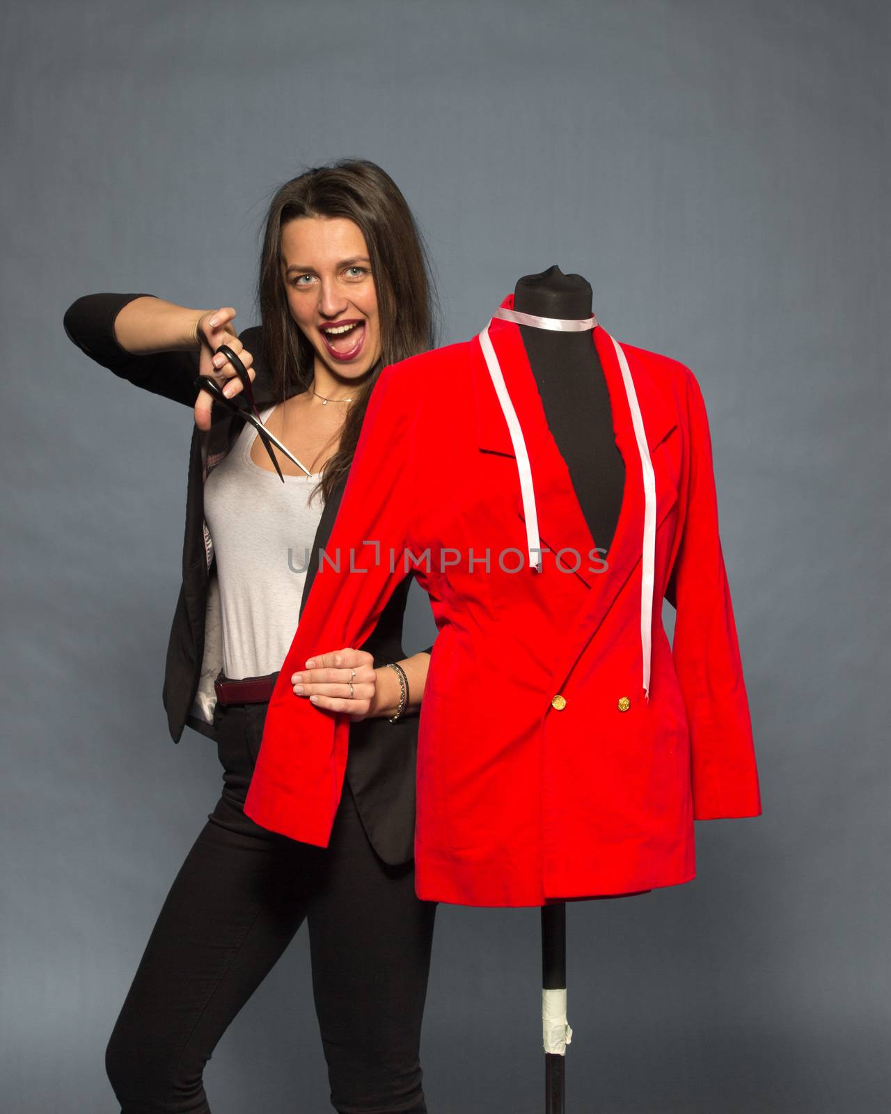 Young woman going to cut the sleeve from red jacket