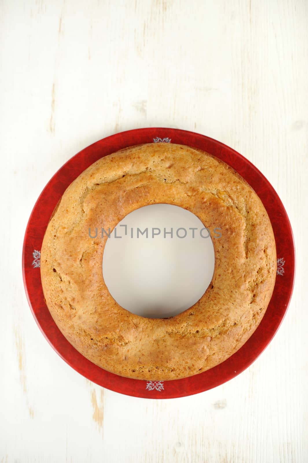 Homemade wreath cake on red plate with white space background