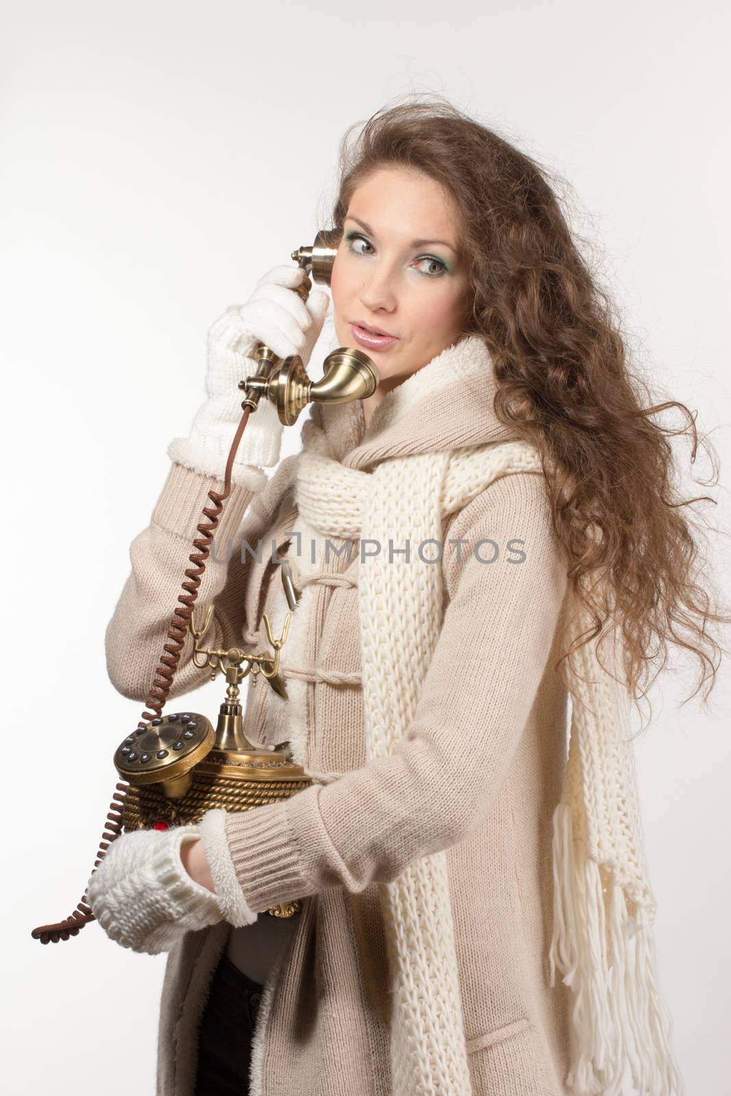 Pretty woman with vintage telephone on grey