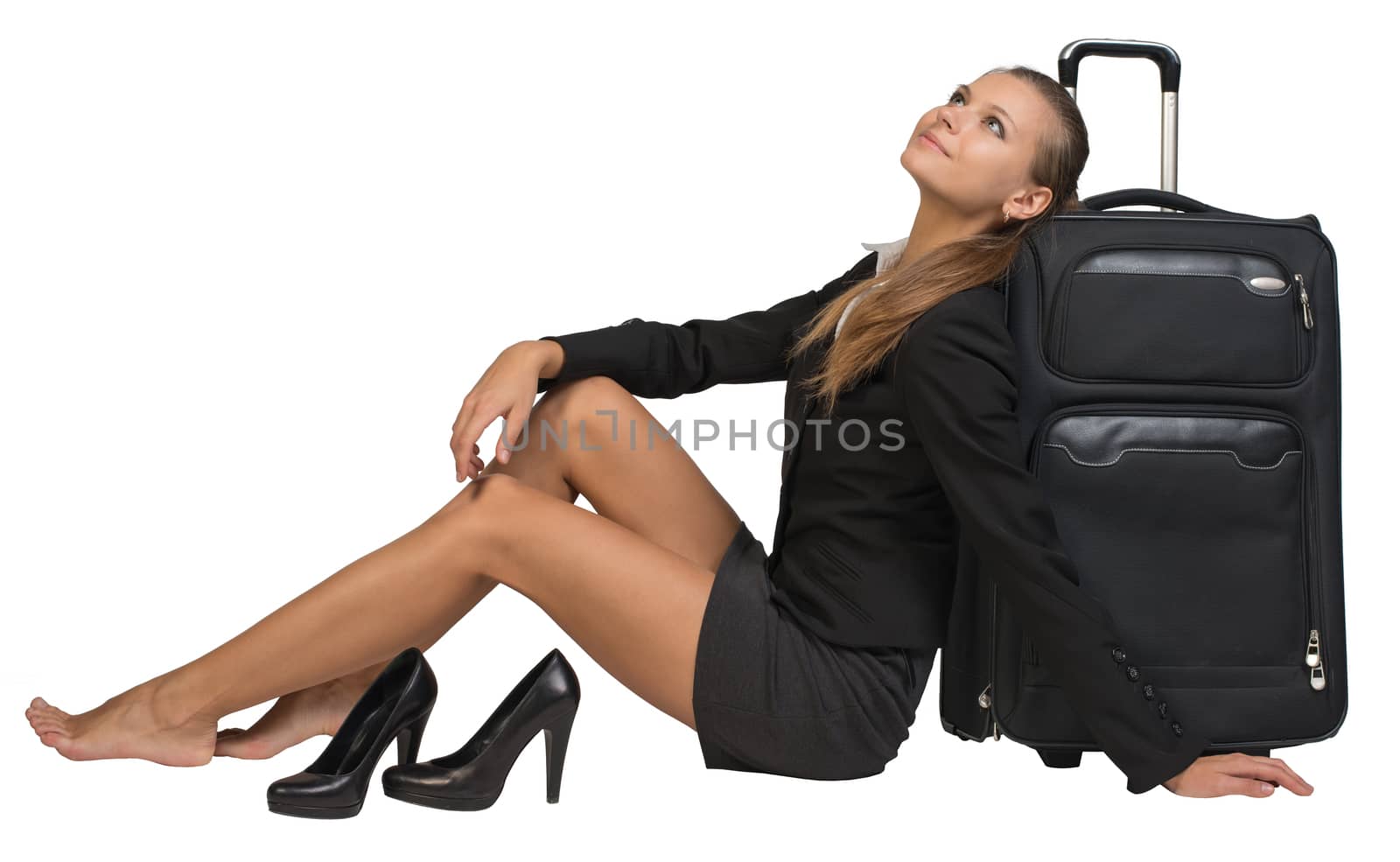 Businesswoman with her shoes off sitting hand resting on the floor, next to front view suitcase with extended handle, looking upwards. Isolated over white background