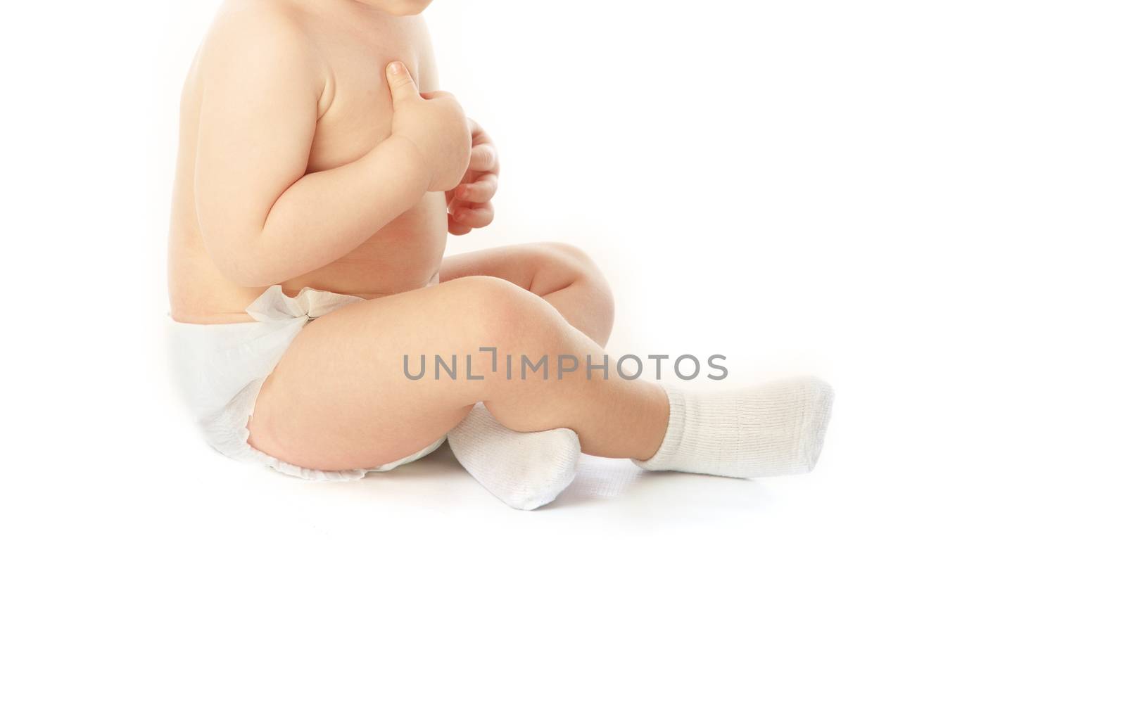Little unrecognizable child in pampers and socks on a white background