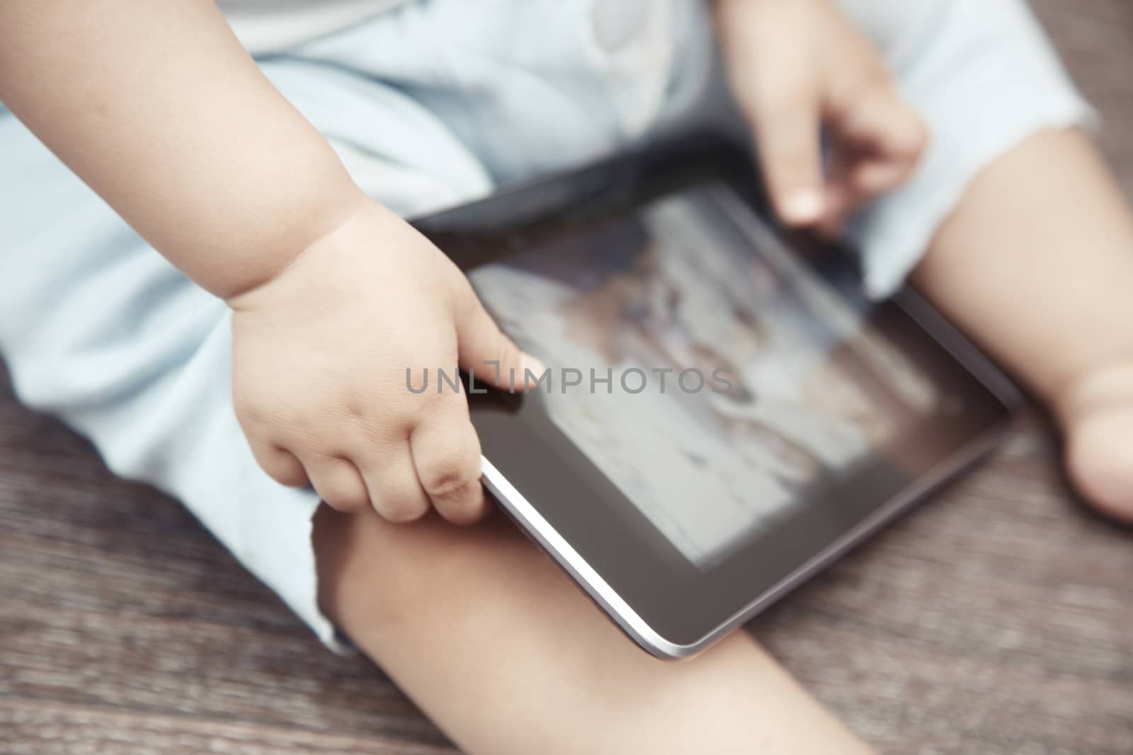Baby with tablet computer. Close-up photo of the hands
