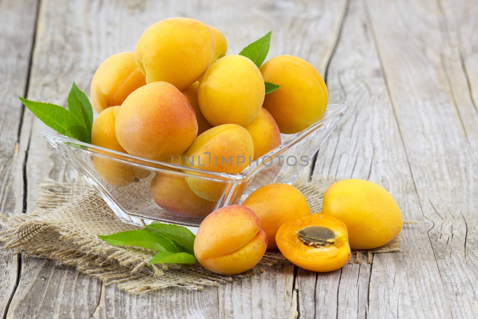 fresh apricots in a bowl on wooden background