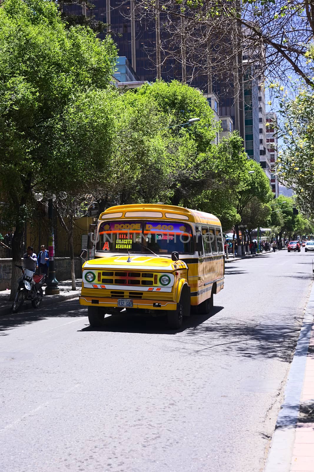 LA PAZ, BOLIVIA - OCTOBER 16, 2014: Old yellow Dodge D400 bus used for public transportation driving on El Prado avenue in the city center on October 16, 2014 in La Paz, Bolivia 