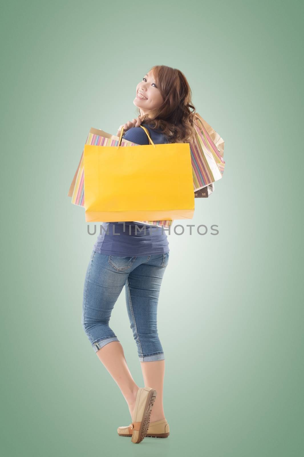 Cheerful shopping woman of Asian holding bags, isolated.