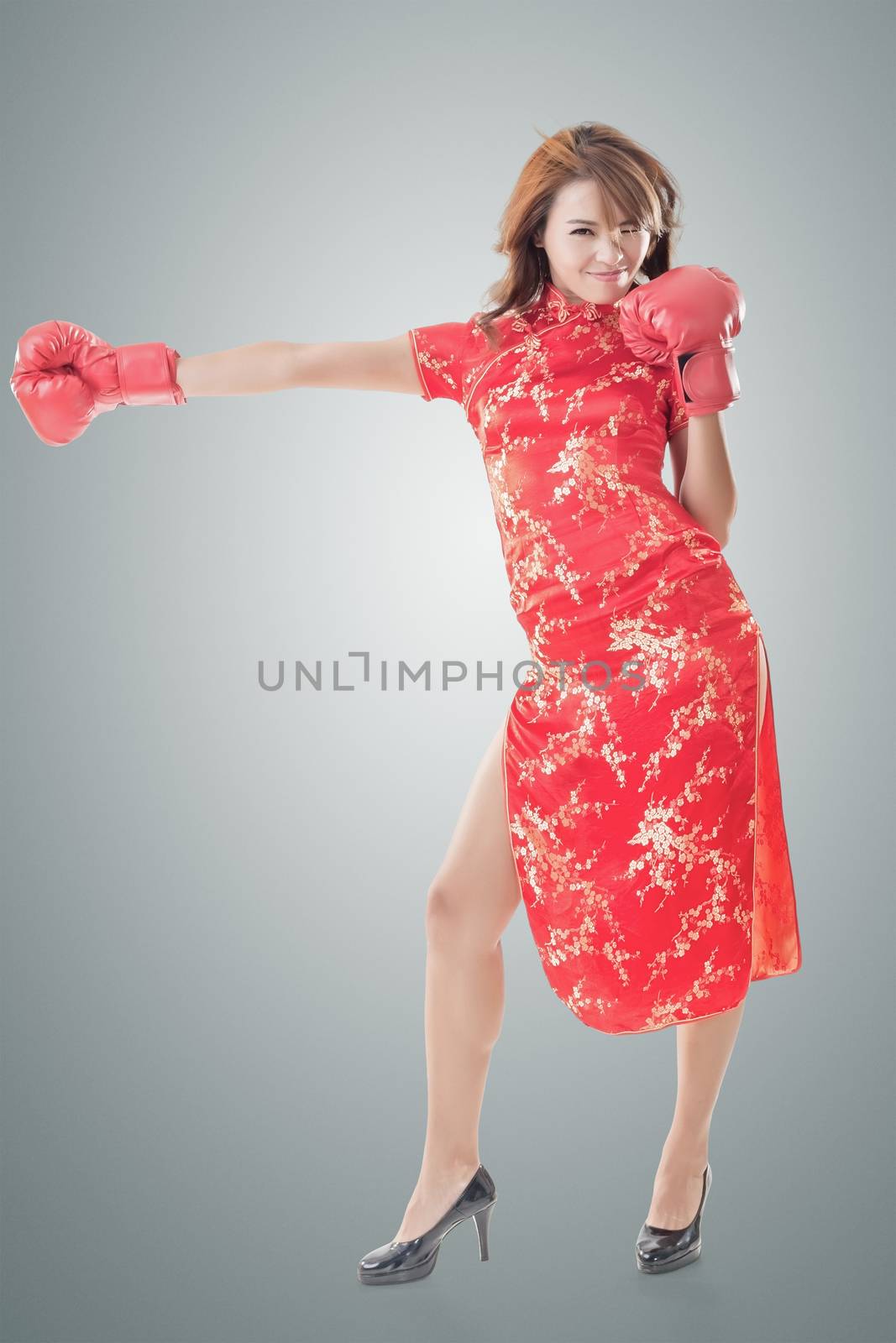 Chinese woman dress traditional cheongsam and boxing gloves, full length portrait isolated.