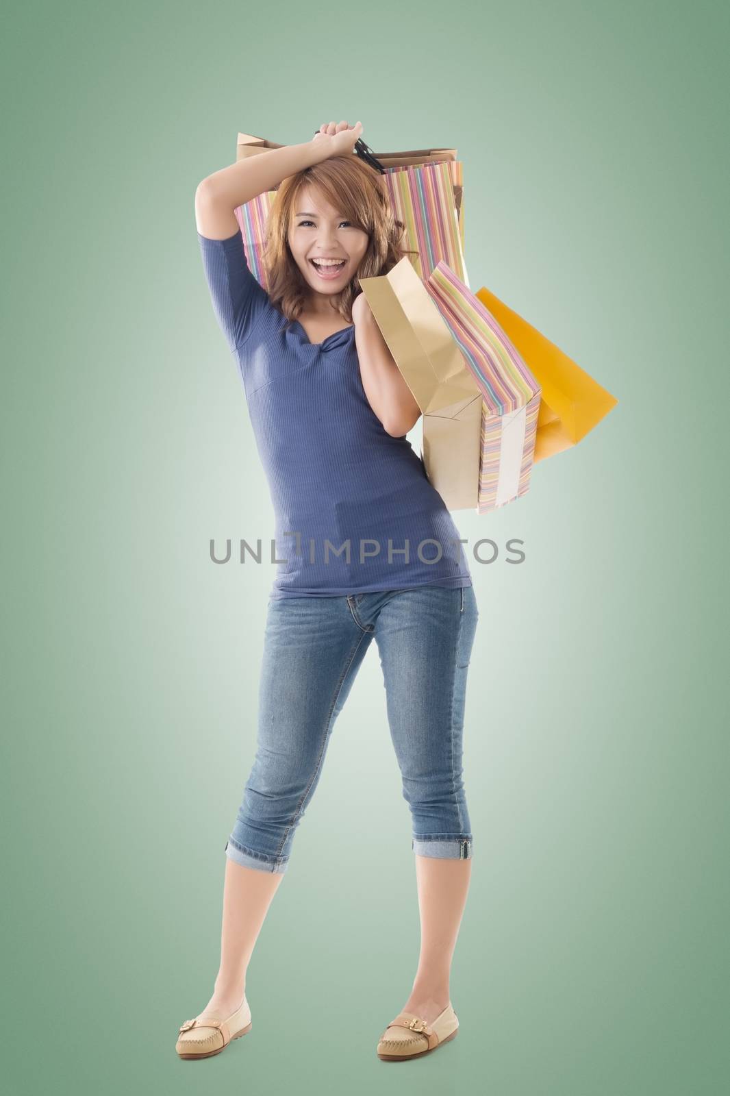 Cheerful shopping woman of Asian holding bags, isolated.