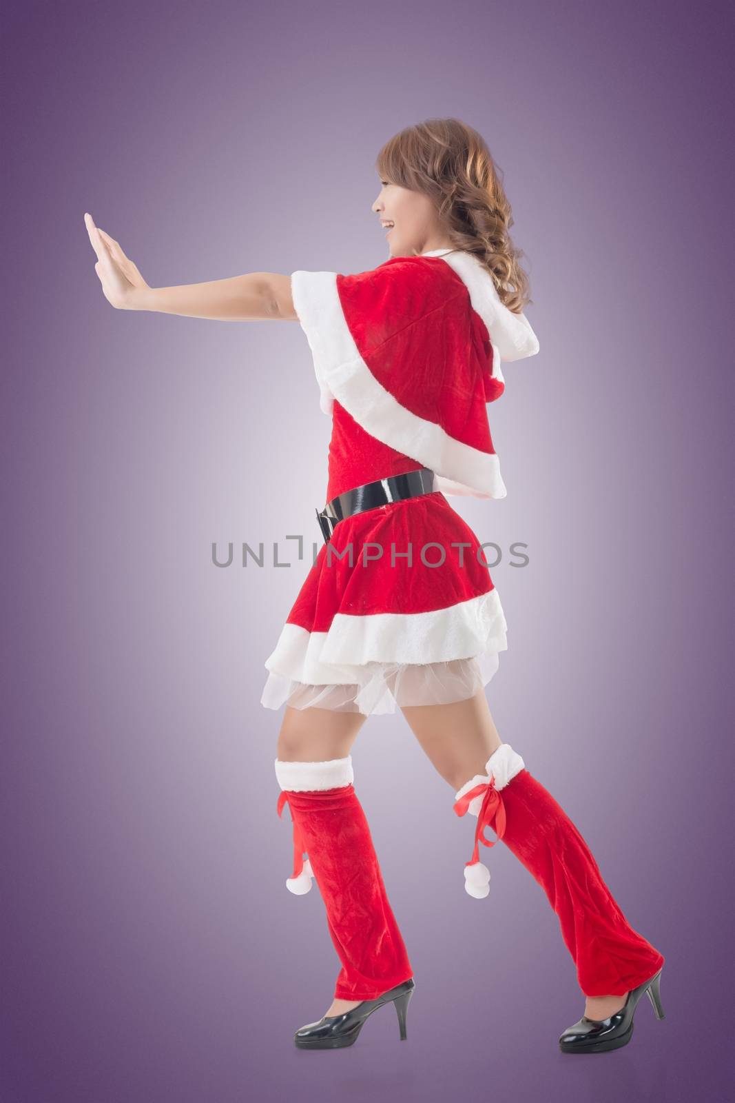 Christmas girl push something, full length pose isolated.