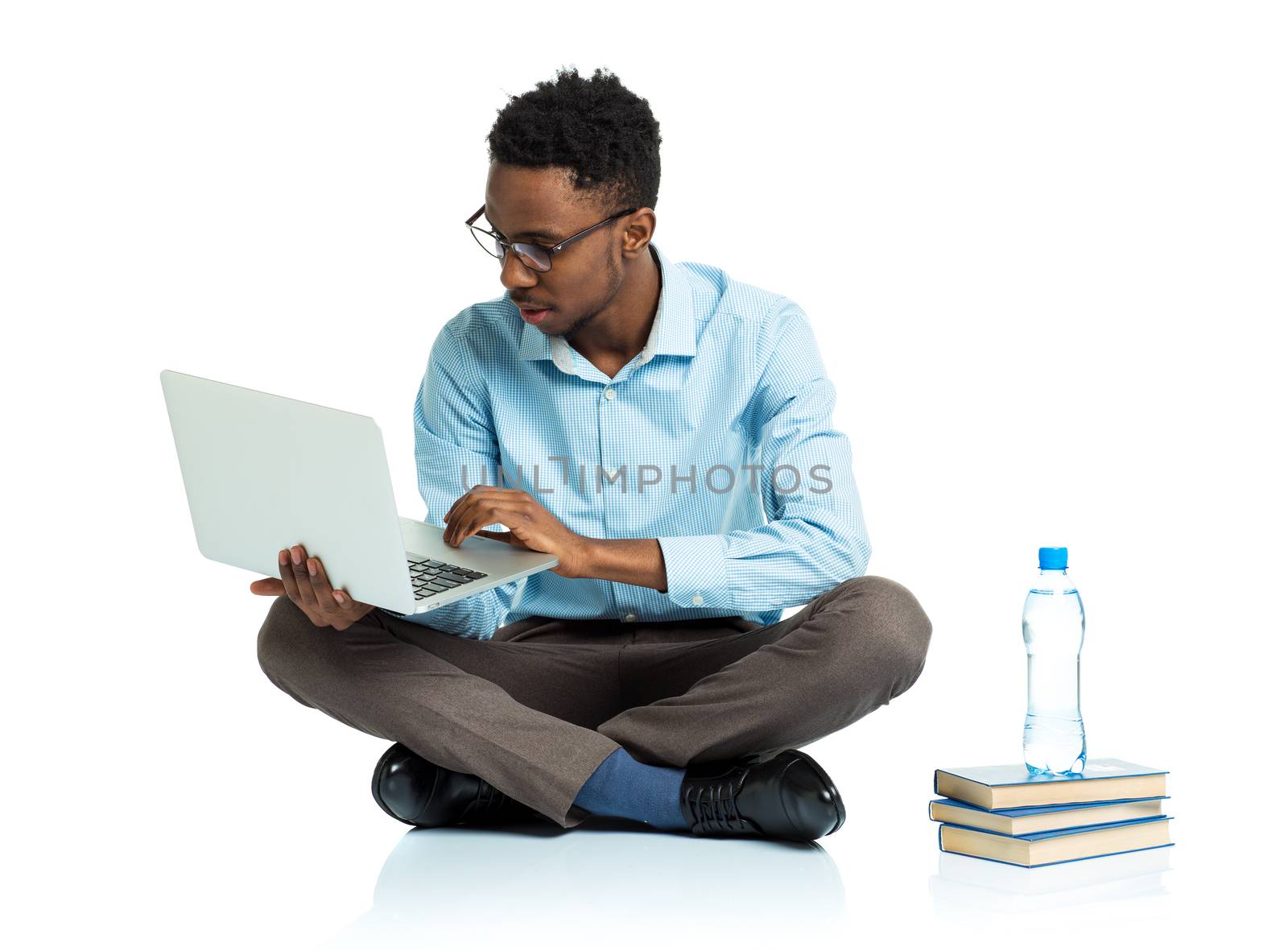 Happy african american college student sitting with laptop on white background