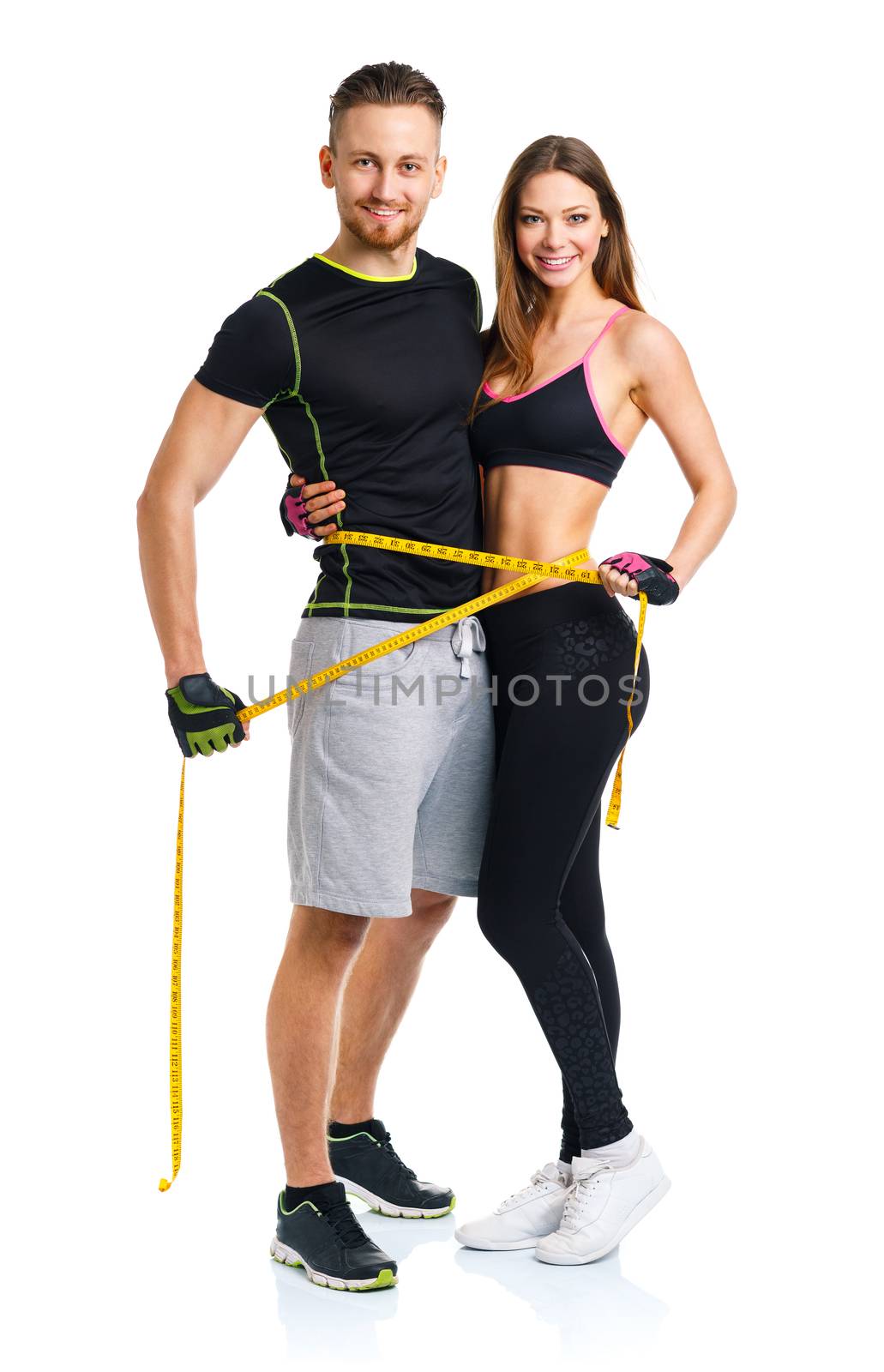 Happy athletic couple - man and woman with measuring tape on the white background