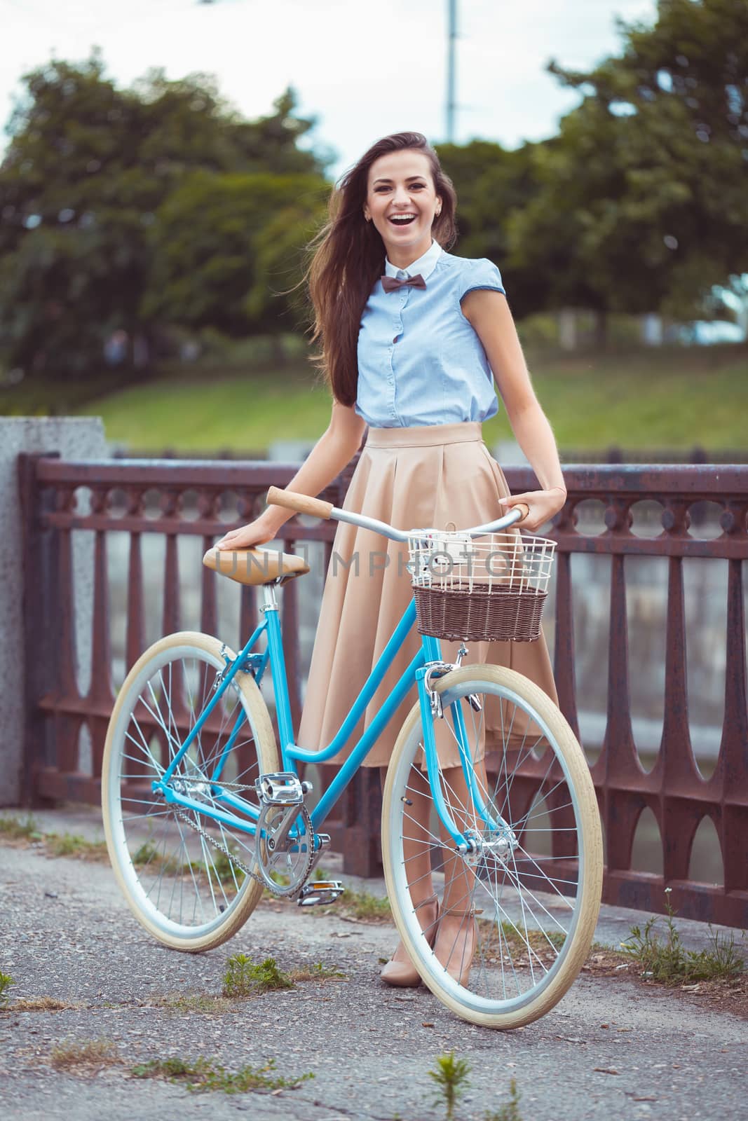 Young beautiful, elegantly dressed woman with bicycle in the par by vlad_star