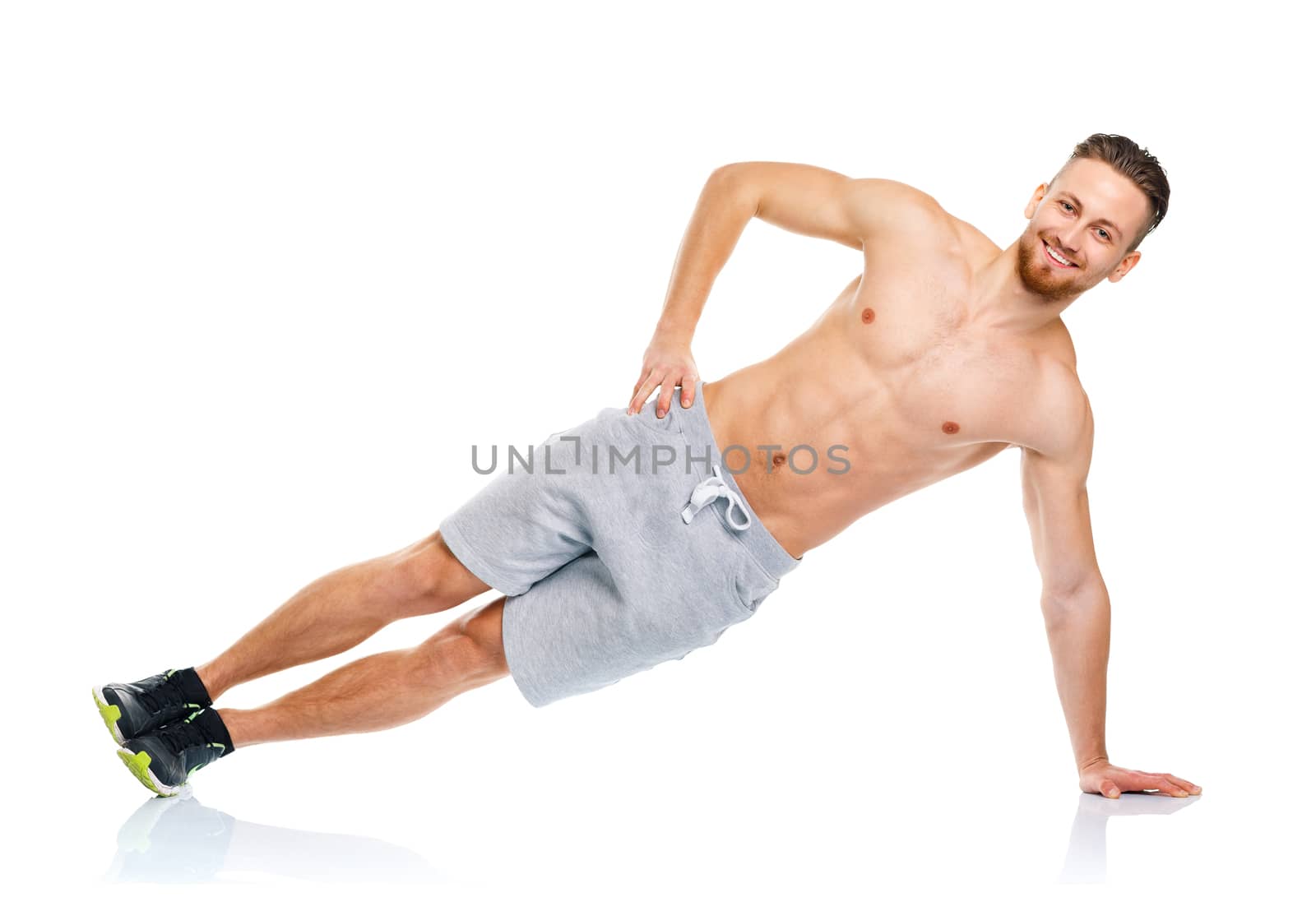 Athletic attractive man doing fitness exercises on the white background