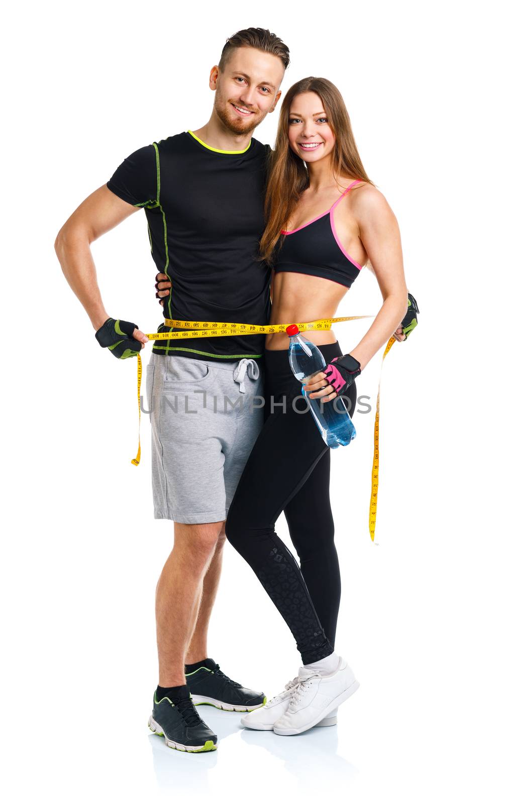 Happy athletic couple - man and woman with measuring tape on the white background